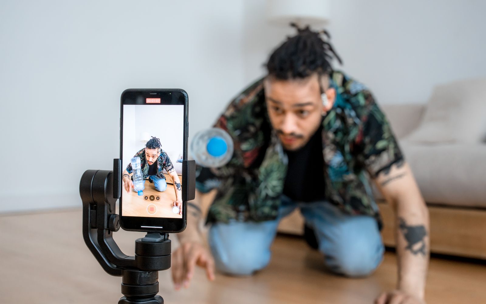 Homem filmando conteúdo criativo com smartphone em um gimbal dentro de um ambiente fechado