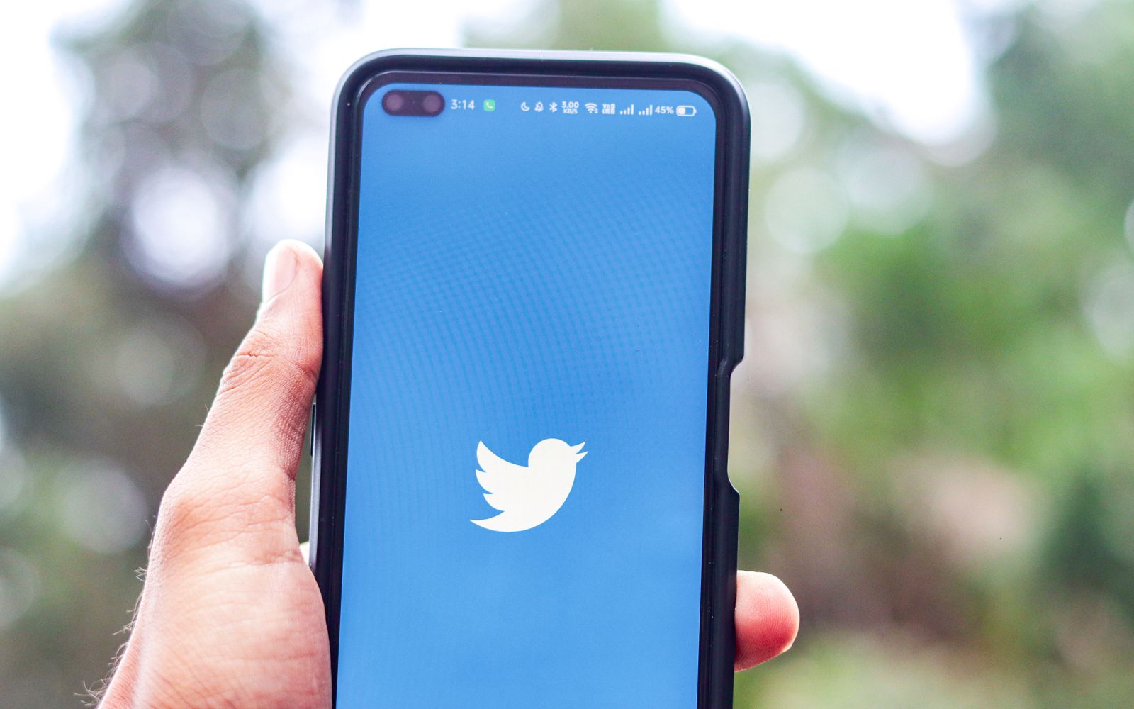 Mão segurando celular com o aplicativo do Twitter aberto