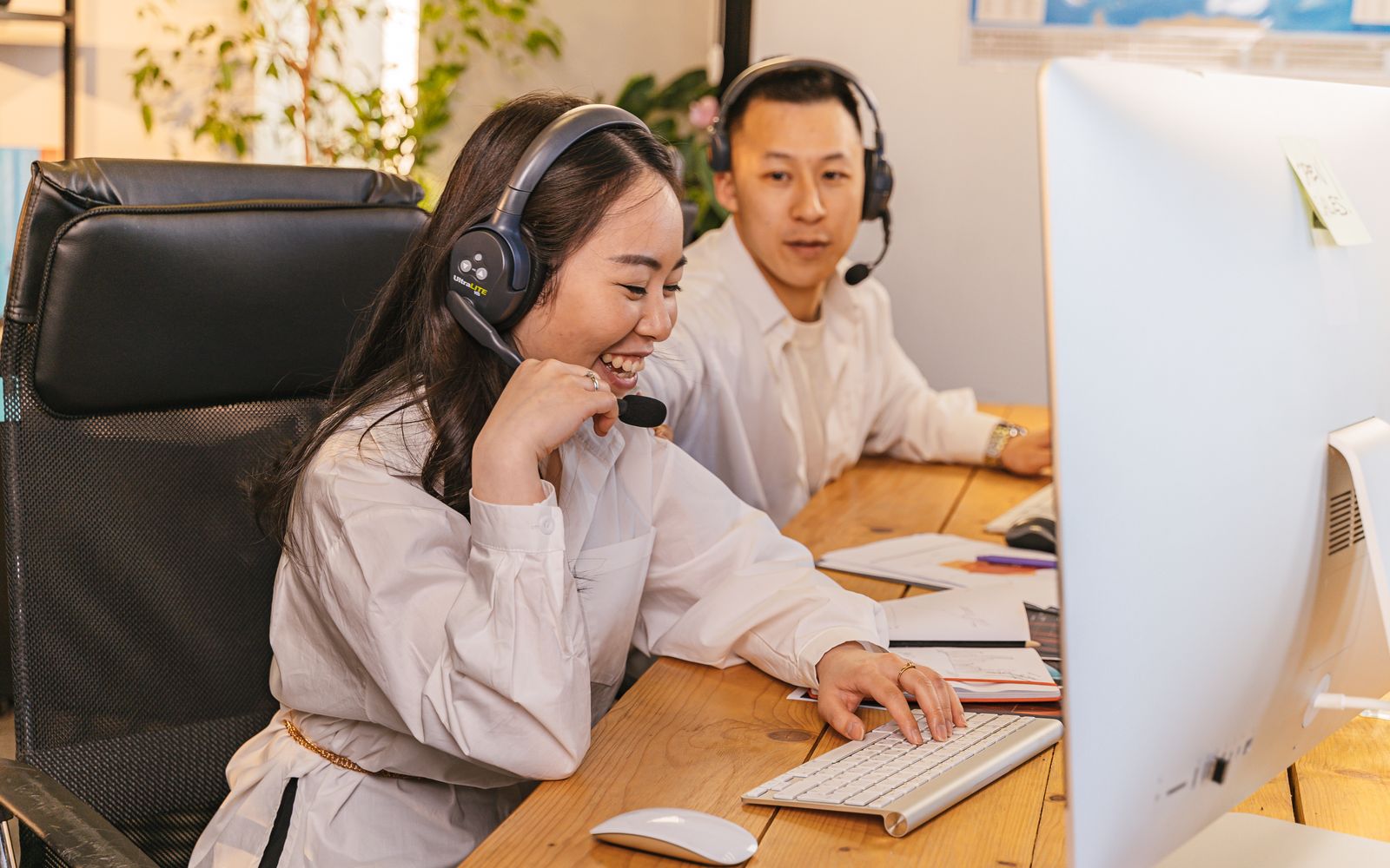 Dois atendentes de headset trabalhando lado a lado