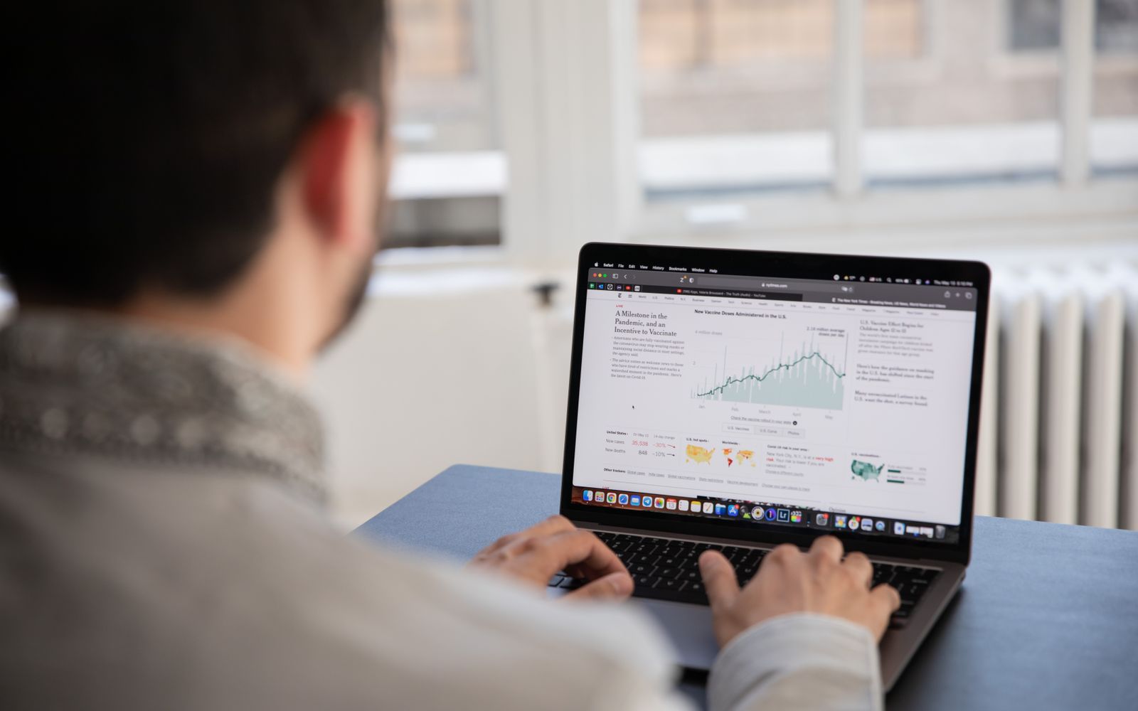 Uma pessoa trabalhando em um laptop analisando dados financeiros em um ambiente interno iluminado