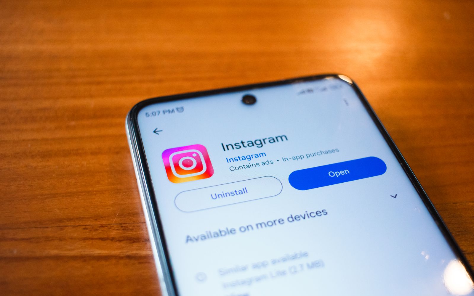 Um smartphone exibindo o aplicativo Instagram com a opção aberta sobre uma mesa de madeira