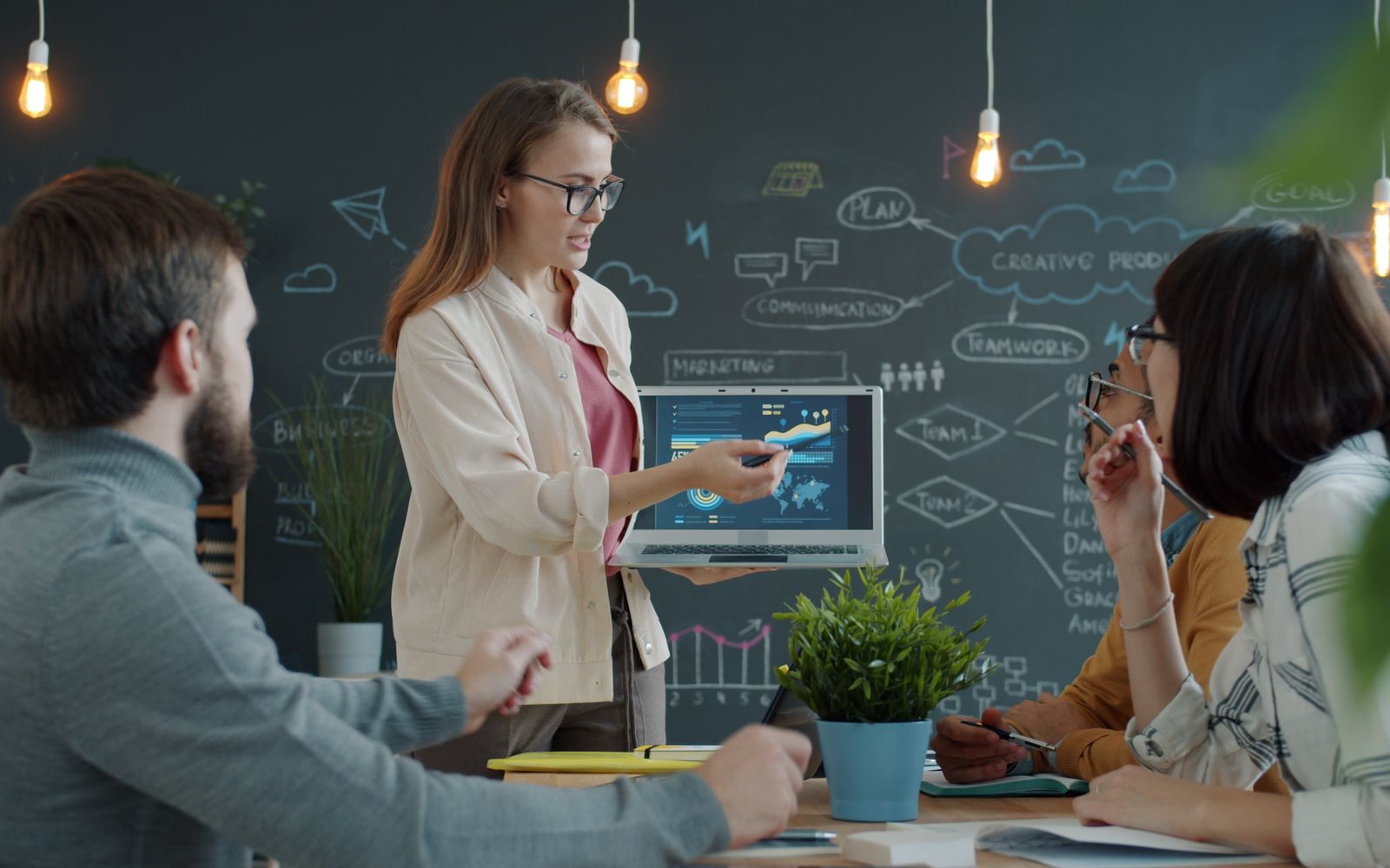 Equipe diversa colaborando com ferramentas digitais em um ambiente de escritório criativo