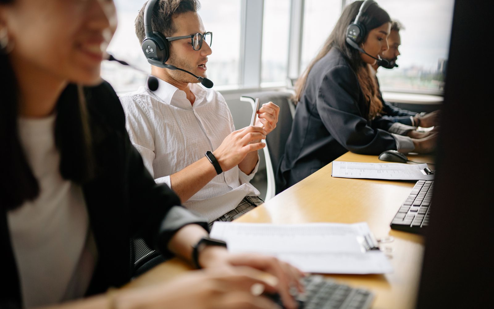 Uma equipe diversa de atendentes de centro de atendimento trabalhando juntos em um ambiente de escritório moderno