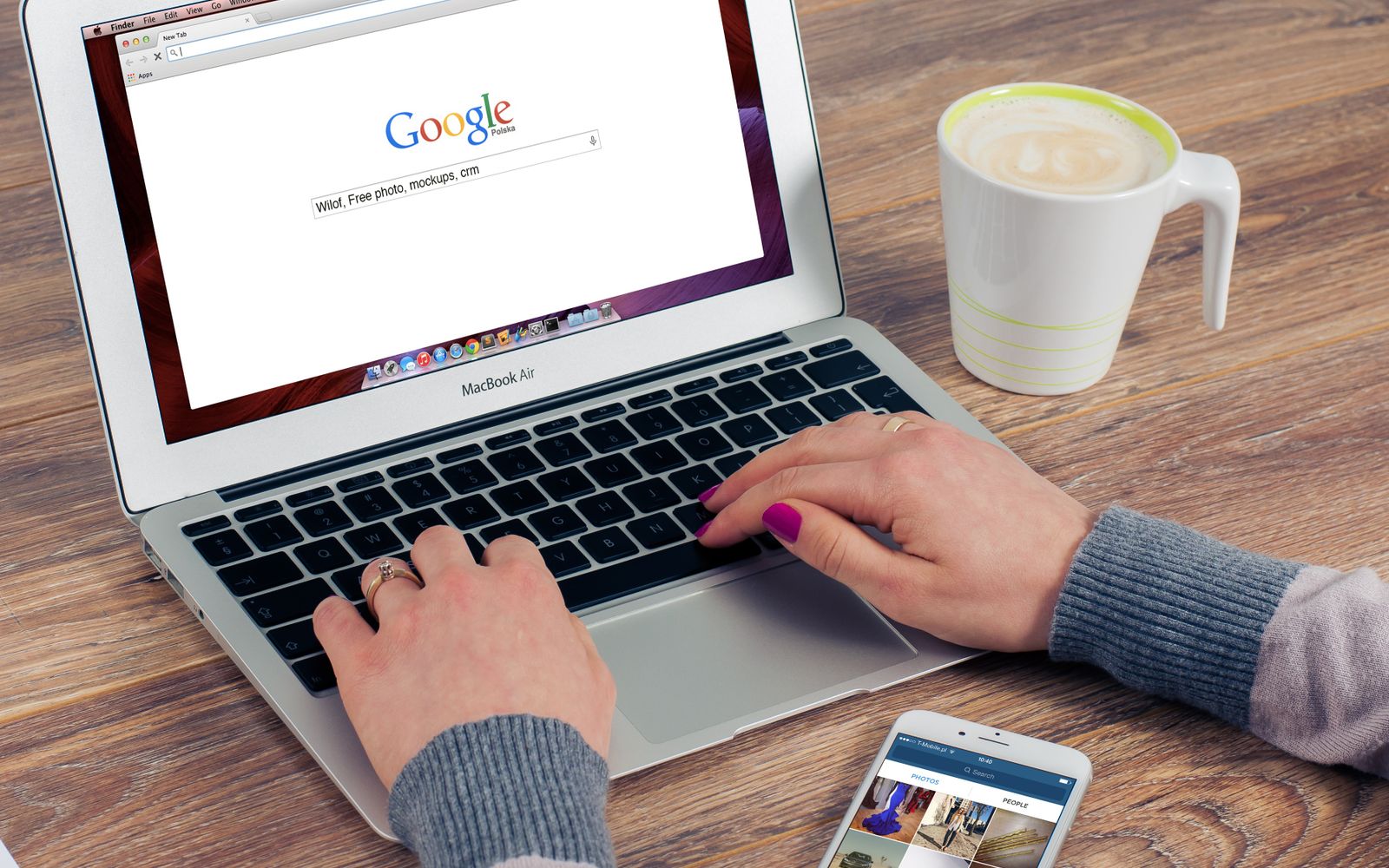 Mãos digitando em um MacBook Air com a busca do Google aberta