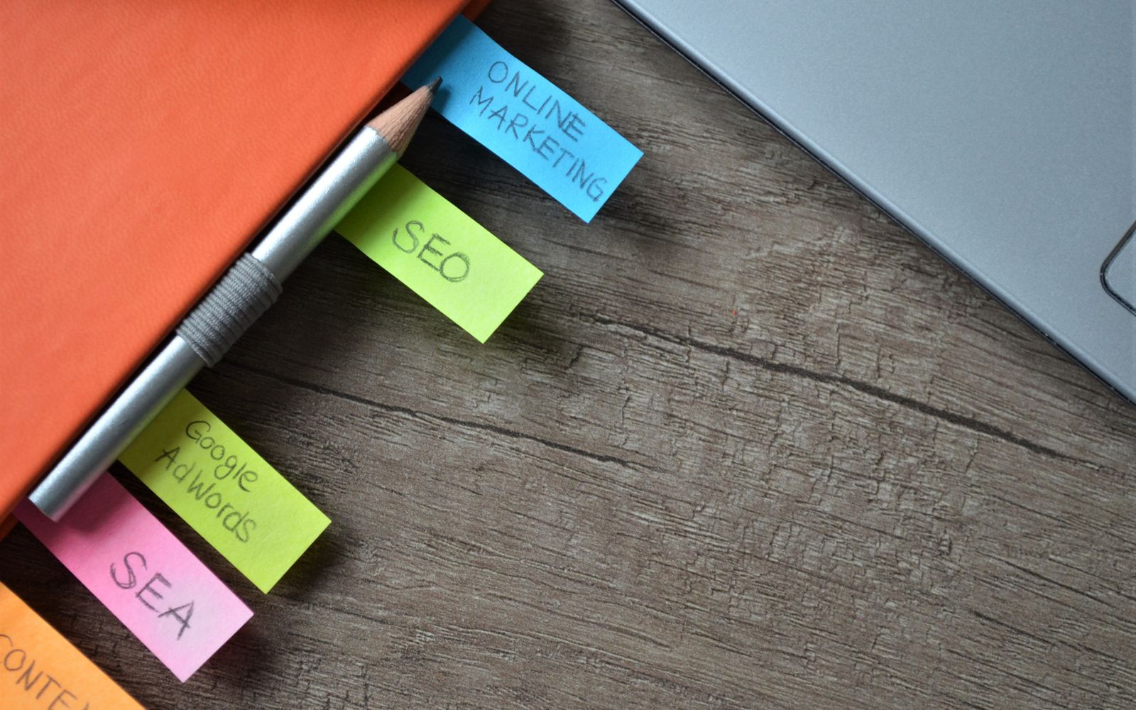 Caderno de planejamento de SEO com post-its coloridos e um lápis