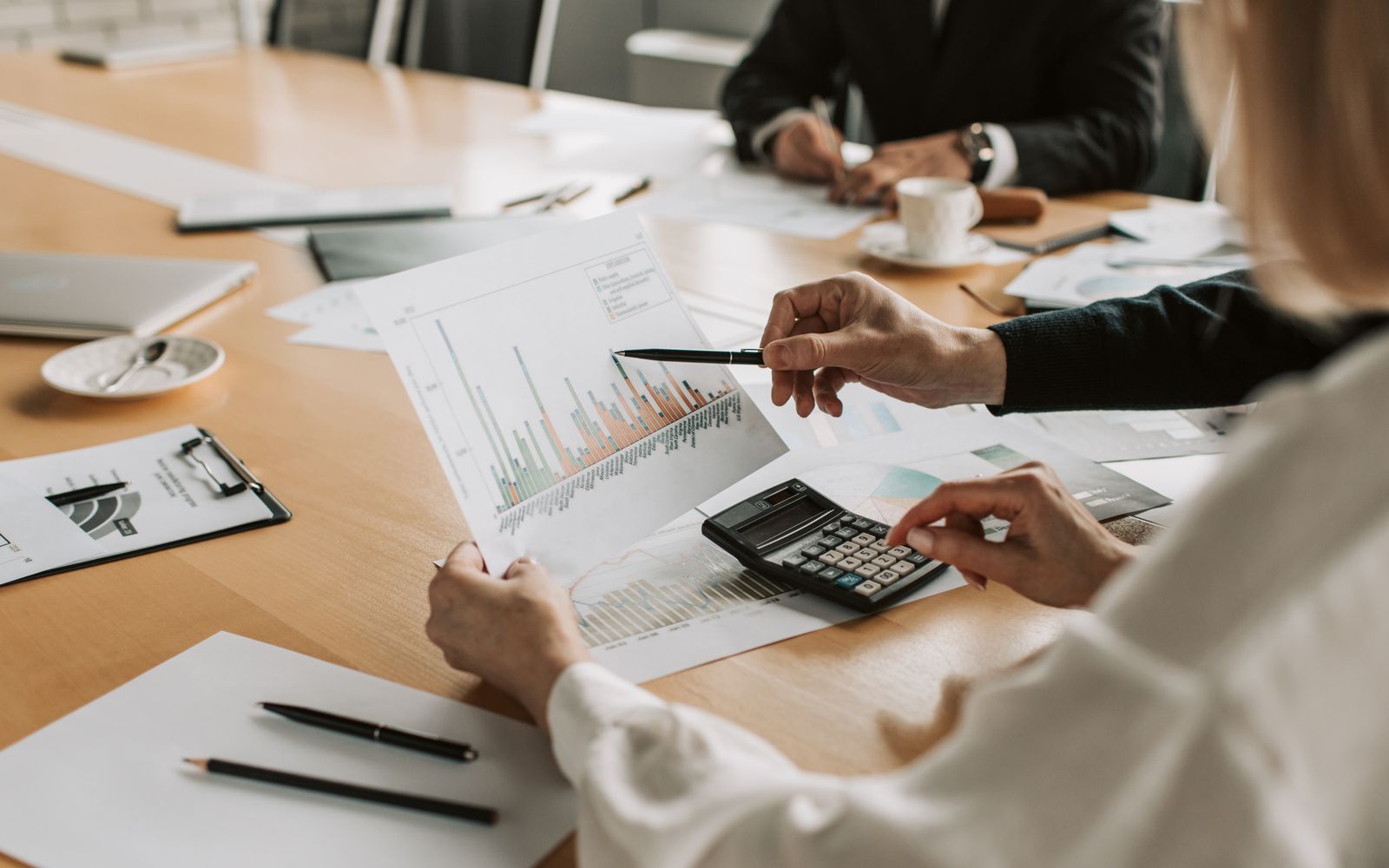 Profissionais revisando gráficos e tabelas financeiras durante uma reunião