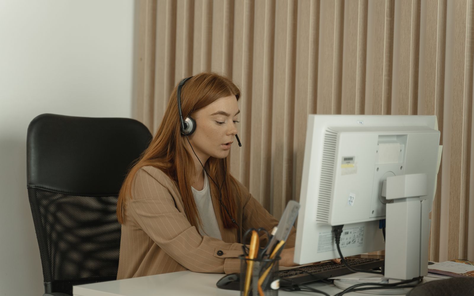 Atendente com headset trabalhando no computador do escritório