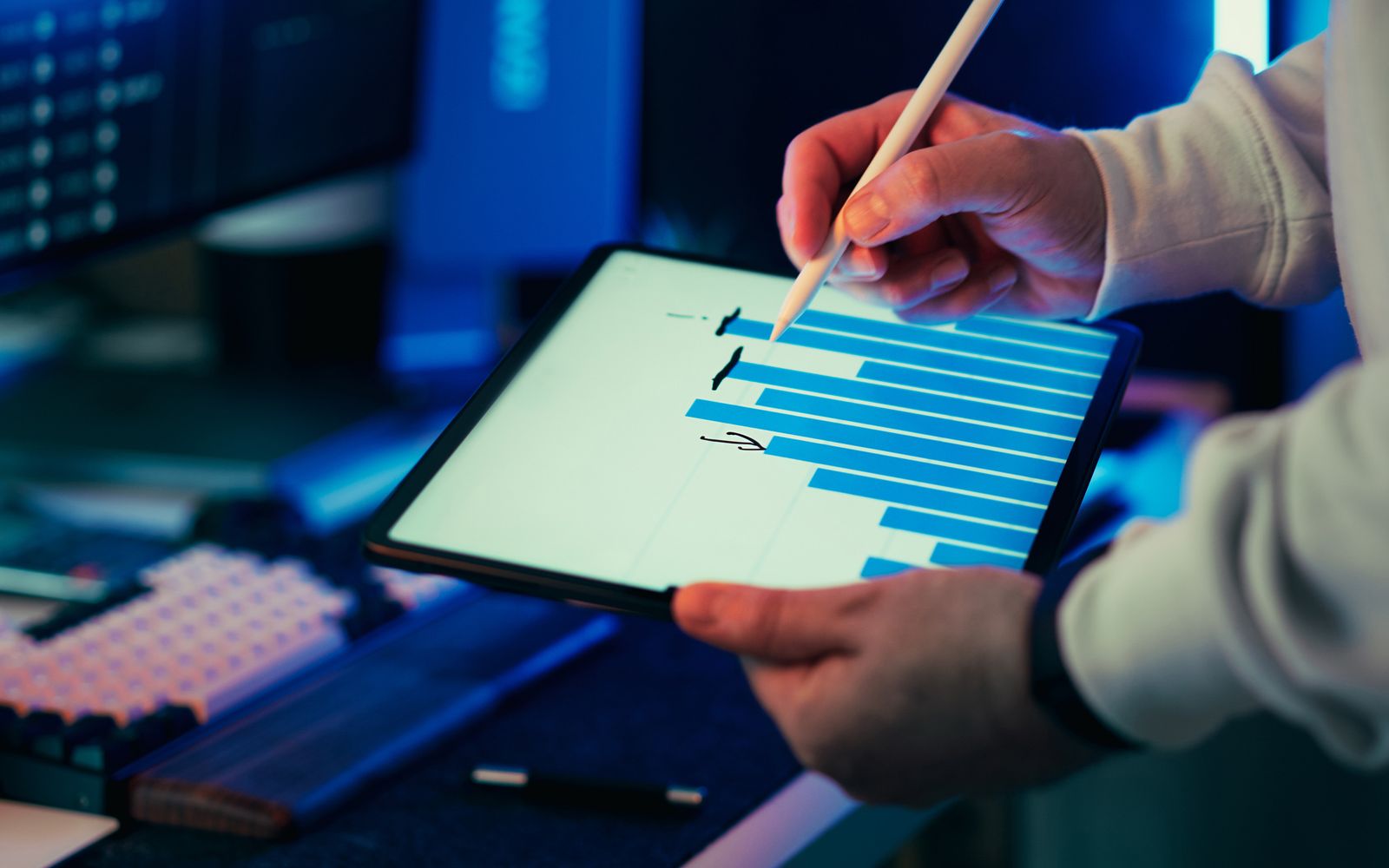 Pessoa usando caneta digital em tablet com um gráfico de negócio