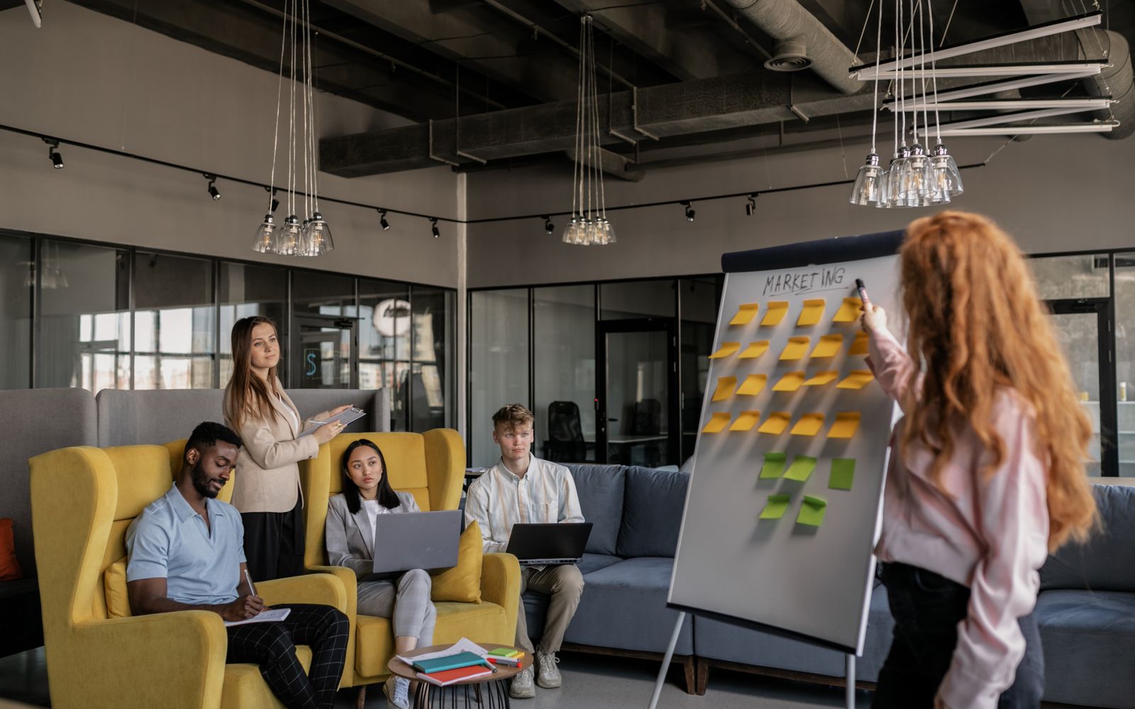 Uma equipe diversa colaborando em uma estratégia de marketing usando um quadro branco com notas adesivas