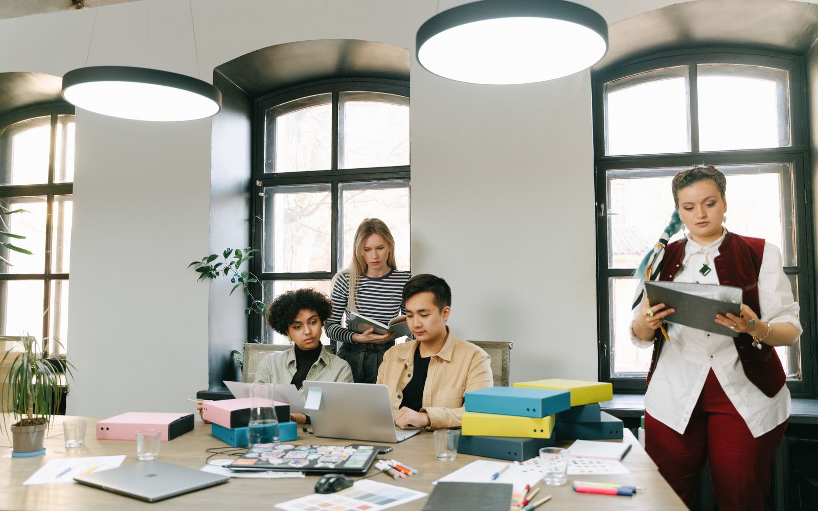 Equipe diversa fazendo brainstorming em um escritório moderno com laptops e documentos