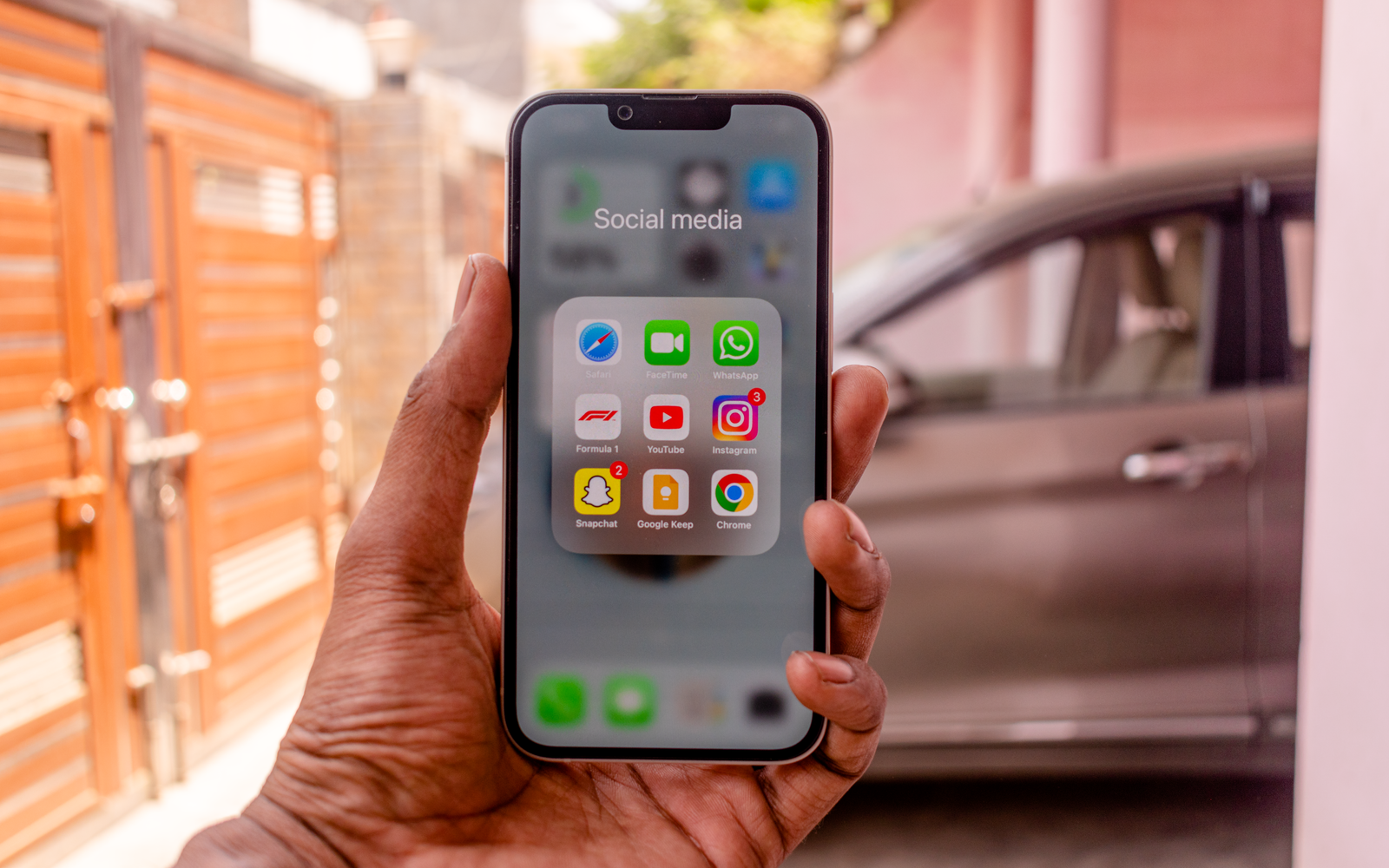 Mão segurando celular com aplicativos de redes sociais ao ar livre