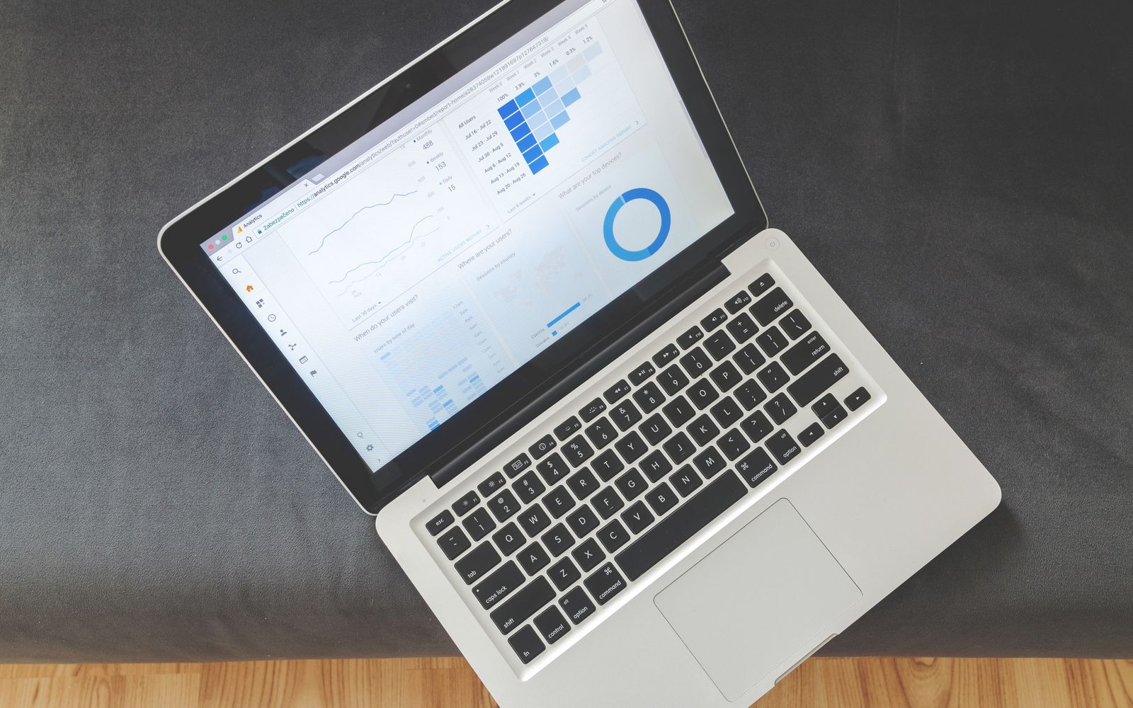 Notebook visto de cima com gráficos e visualizações de dados na tela