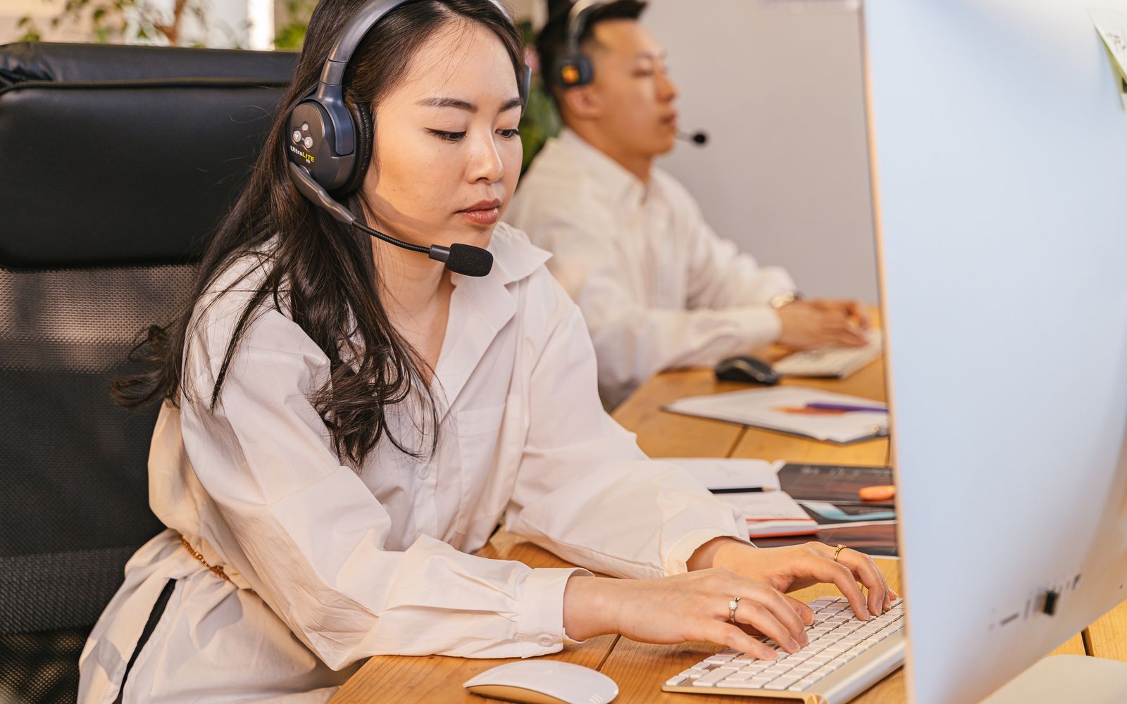 Profissionais de call center concentrados em suas tarefas com fones de ouvido em um ambiente de escritório moderno