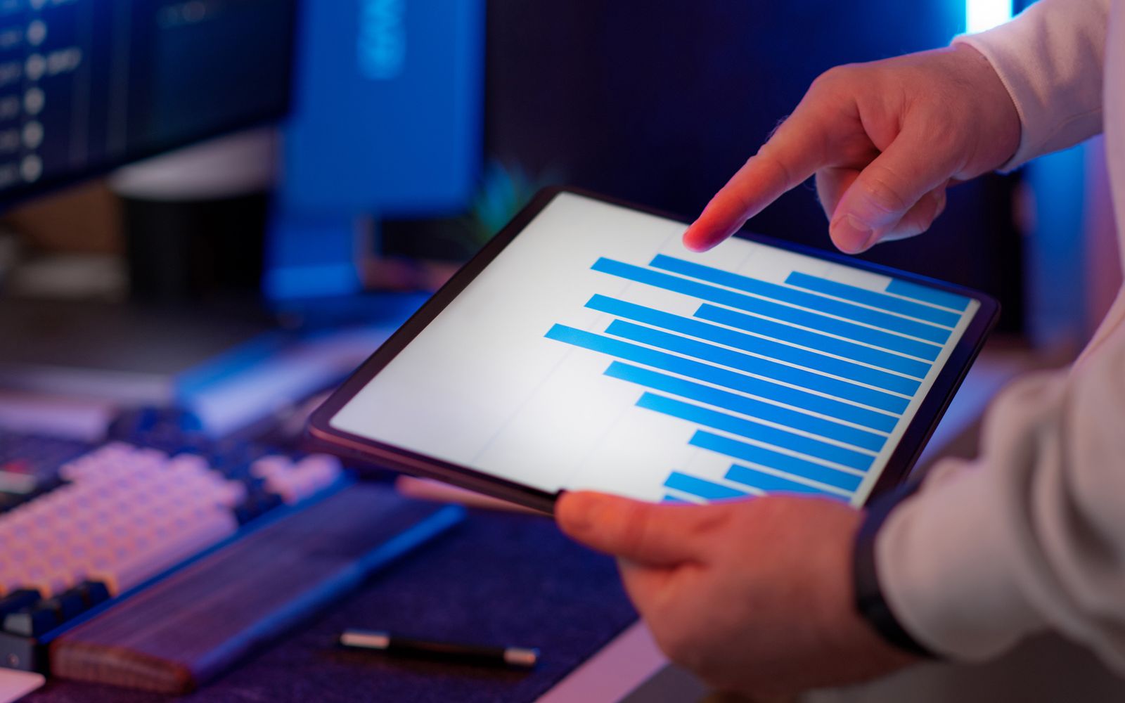 Profissional analisando gráfico de barras em um tablet no escritório