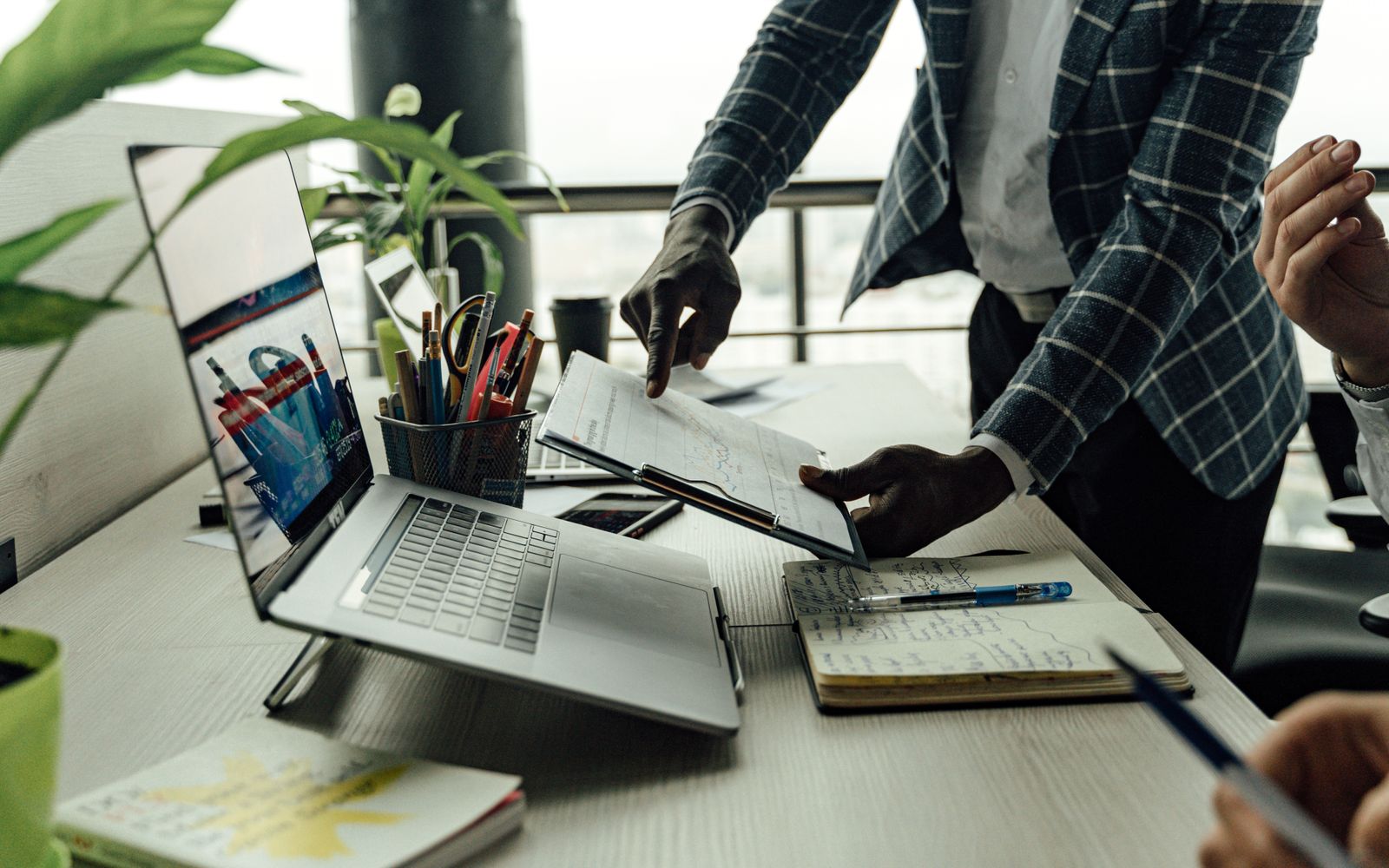 Colegas colaborando na análise de dados financeiros com um laptop no escritório