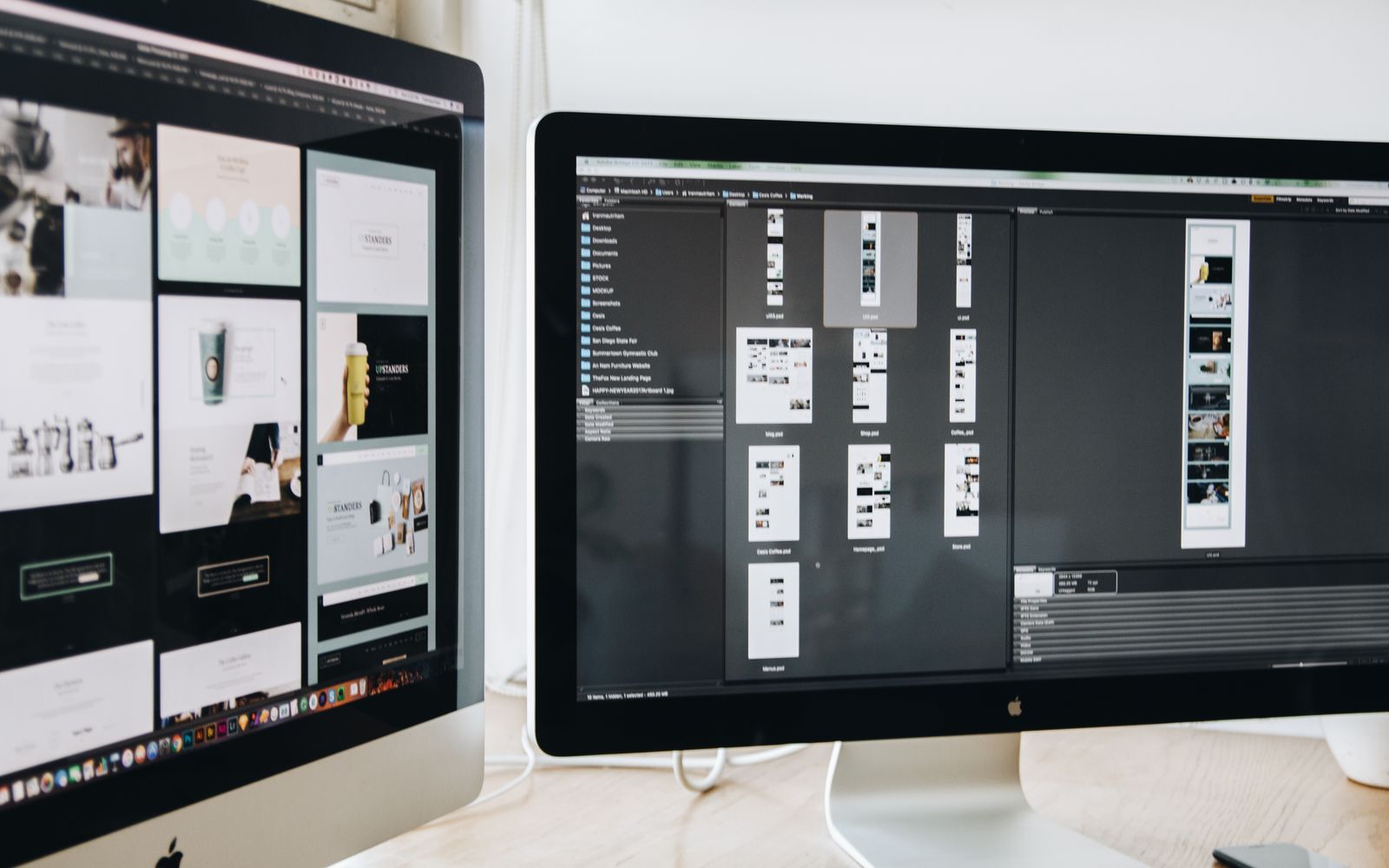 Mesa de trabalho com dois monitores exibindo projetos de web design