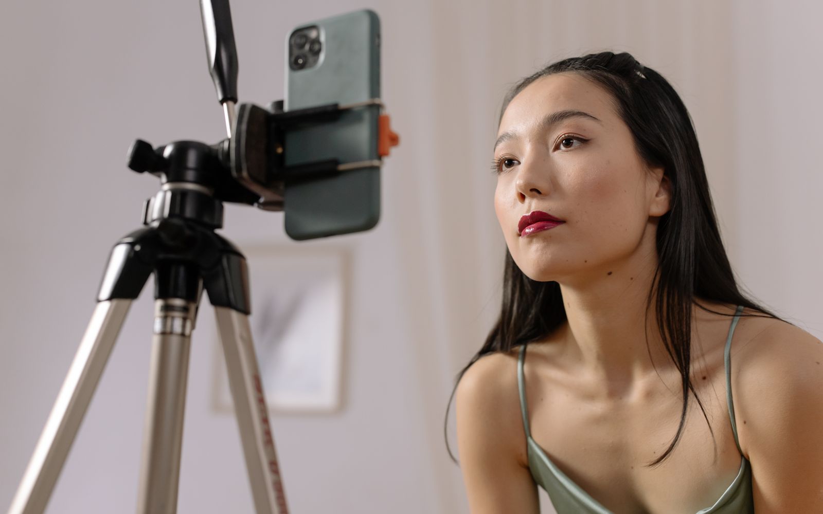 Mulher gravando um vídeo com o celular em tripé