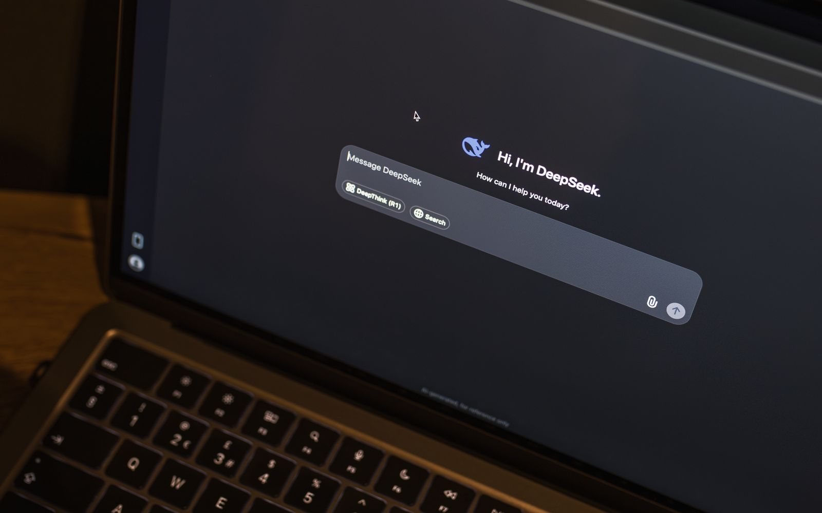 Um laptop em uma mesa de madeira mostra uma interface de chat de IA, com o chatbot DeepSeek em ação
