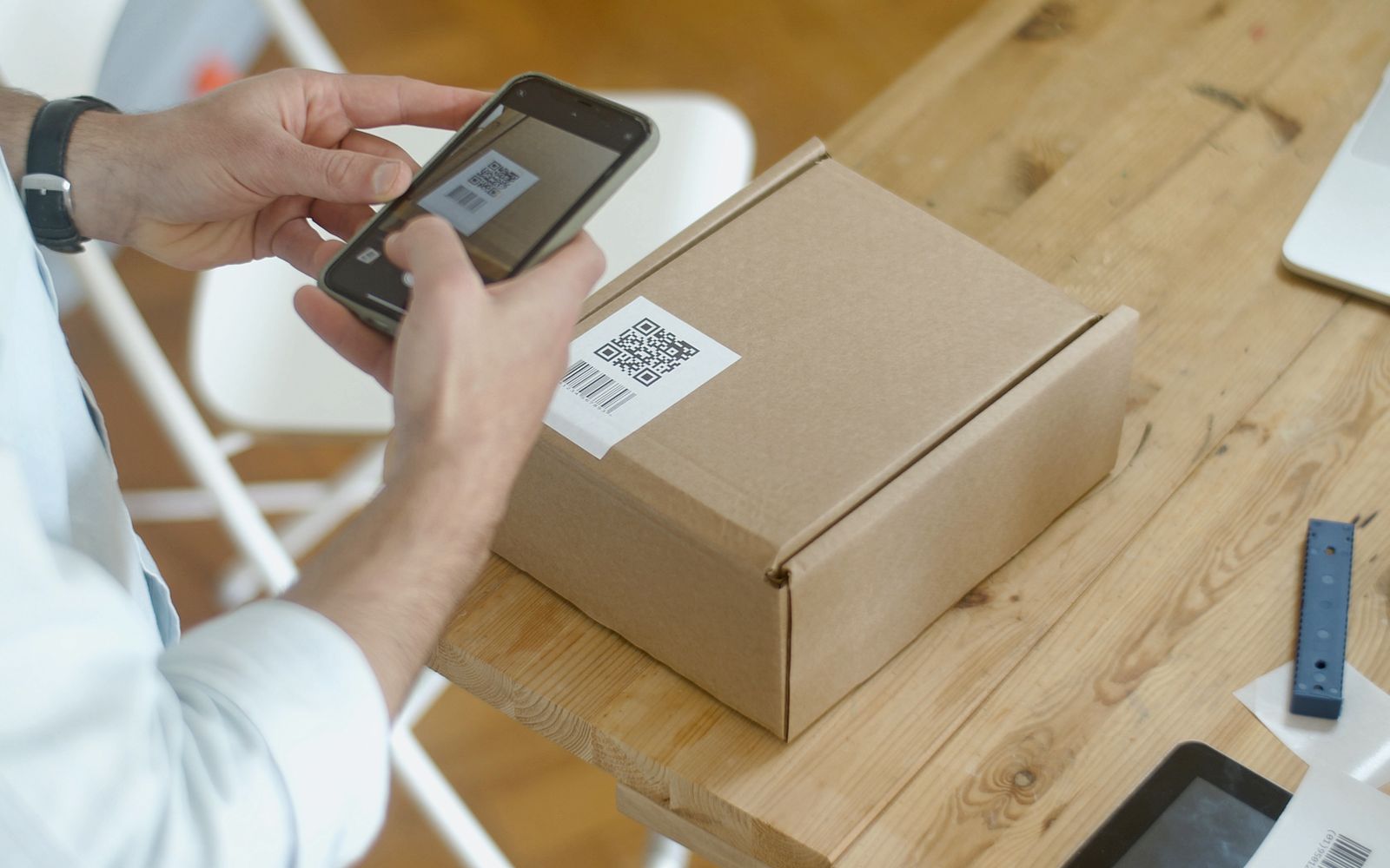 Pessoa lendo o QR code de uma encomenda pelo celular