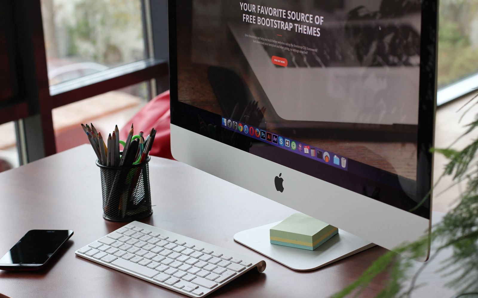 Mesa organizada com monitor, teclado e material de escritório