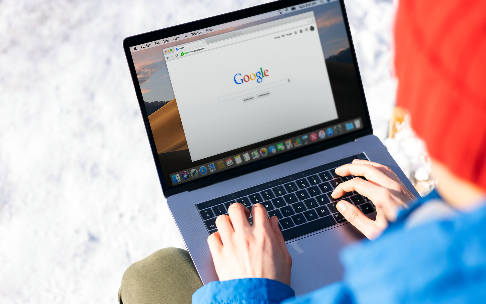 Pessoa digitando em um notebook ao ar livre, na neve