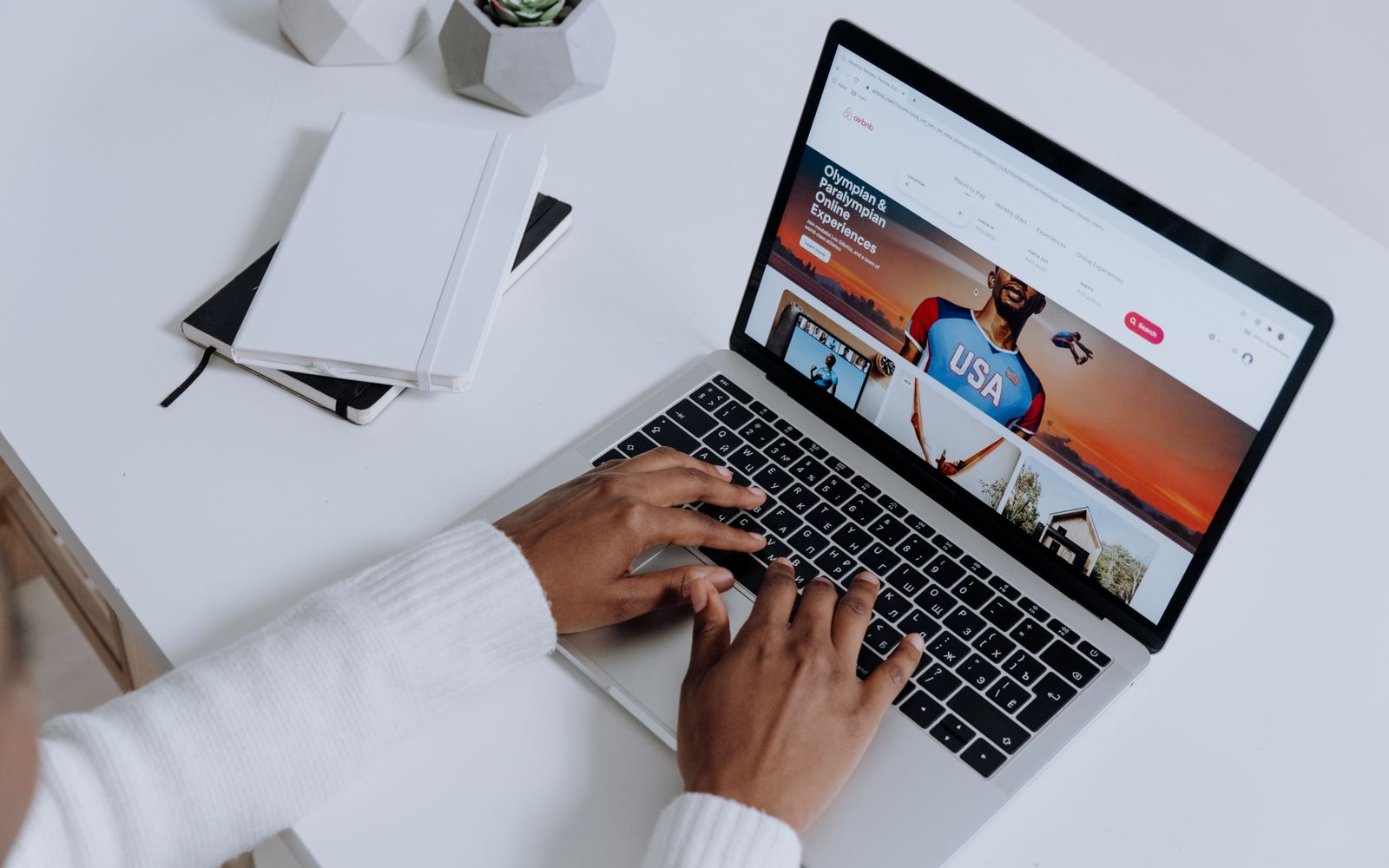Mãos digitando em notebook em ambiente de trabalho minimalista