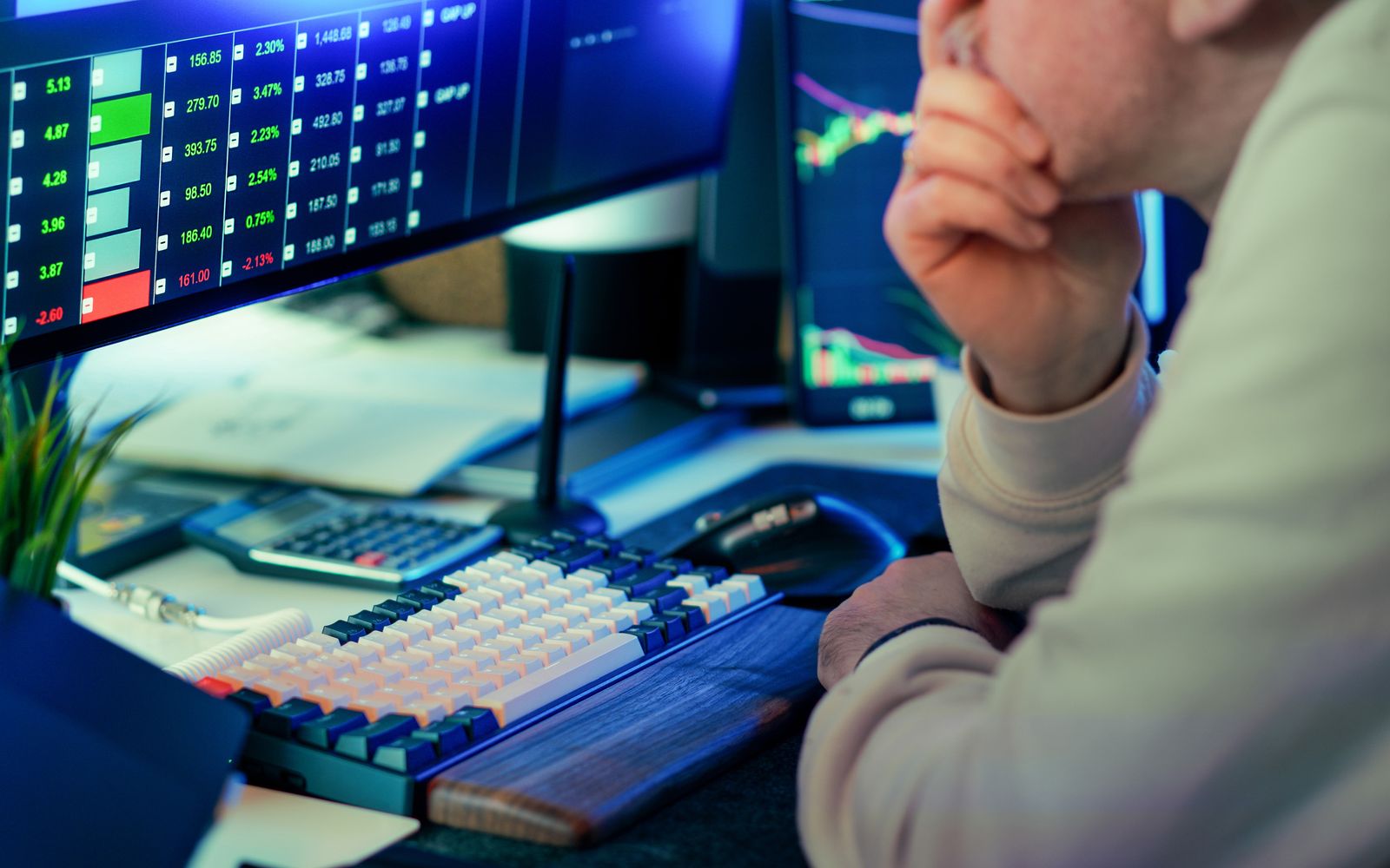 Operador analisando dados de mercado em várias telas