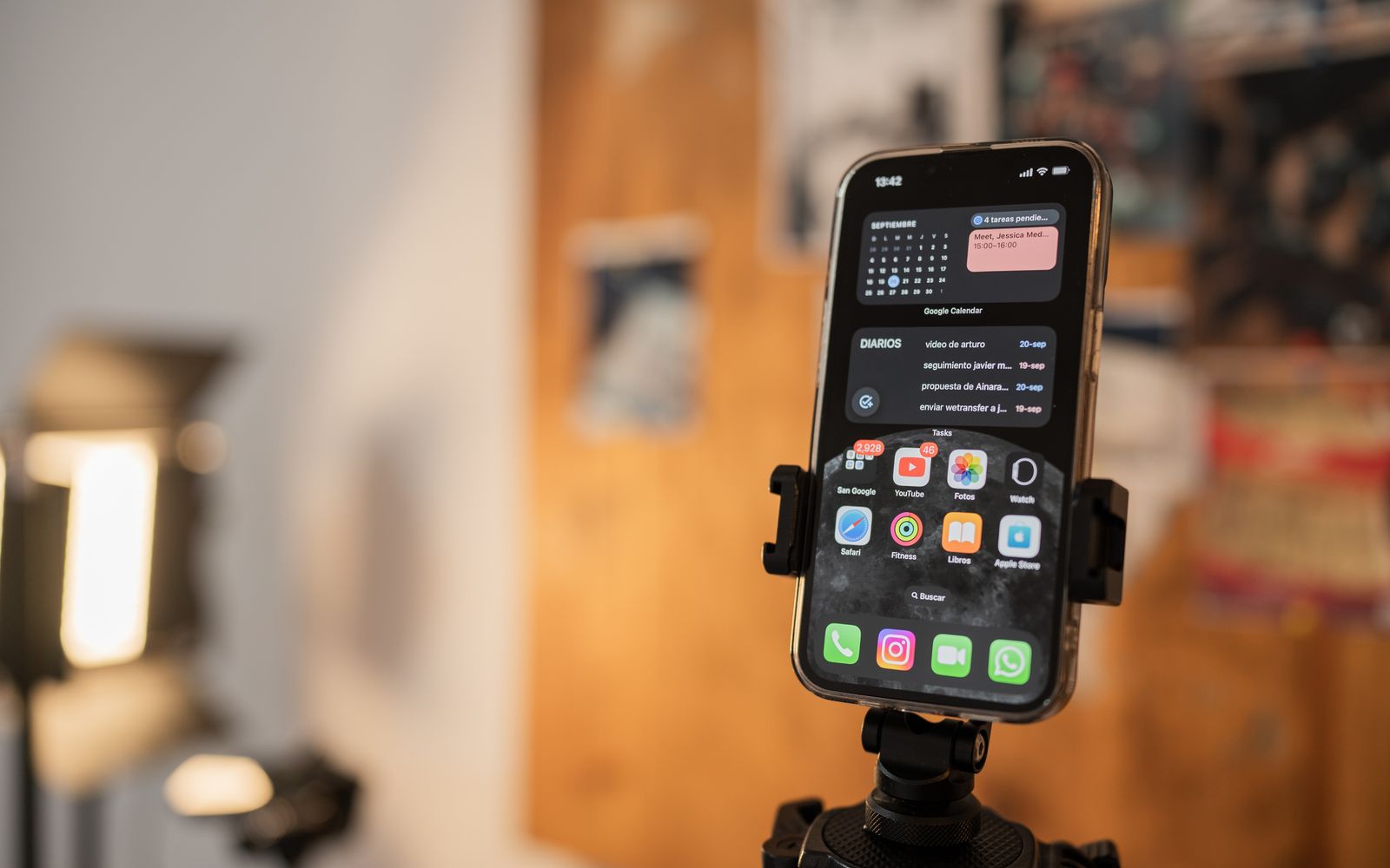 Celular preso a um tripé com os aplicativos abertos na tela