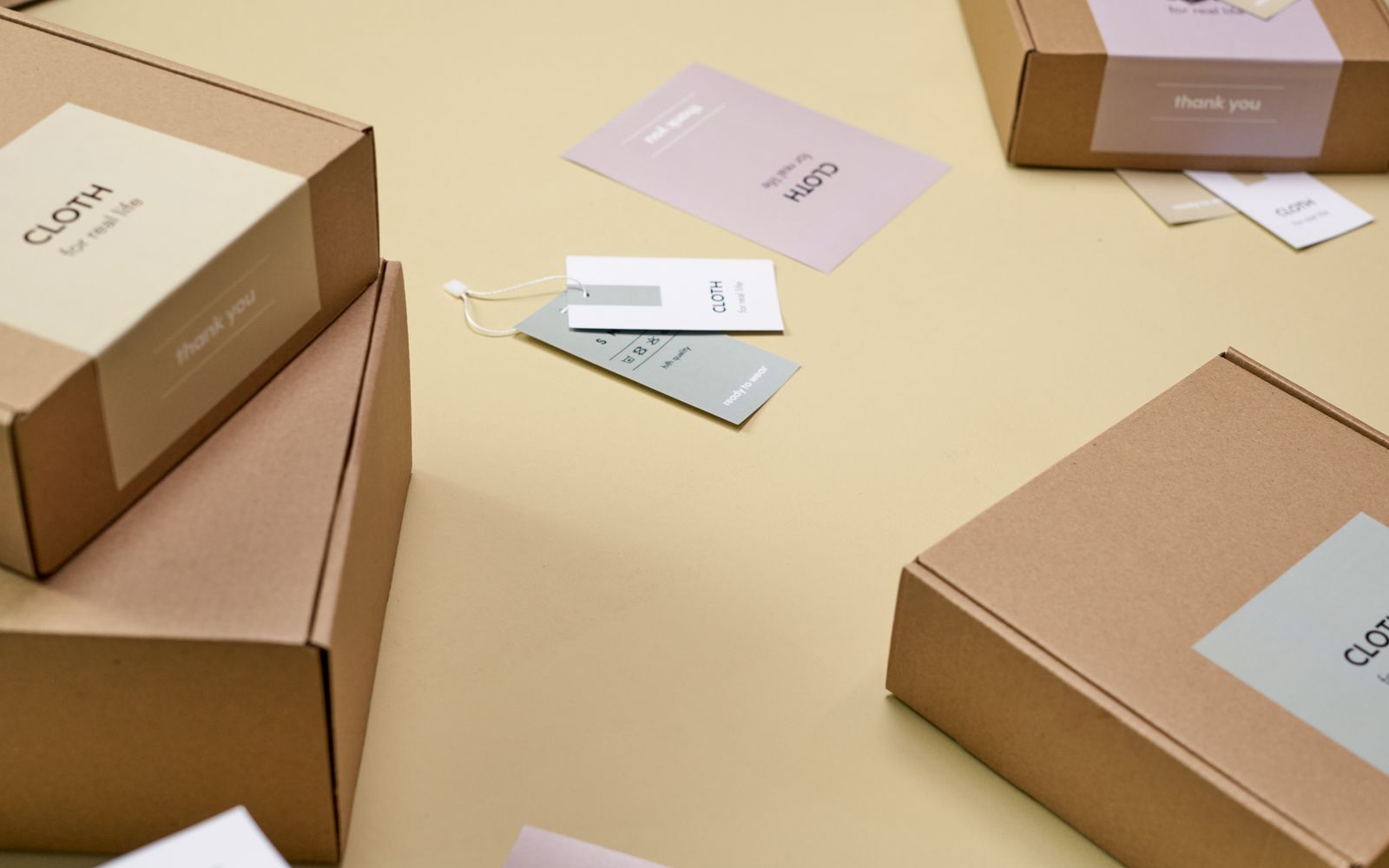 Caixas de papelão com etiquetas sobre superfície amarela