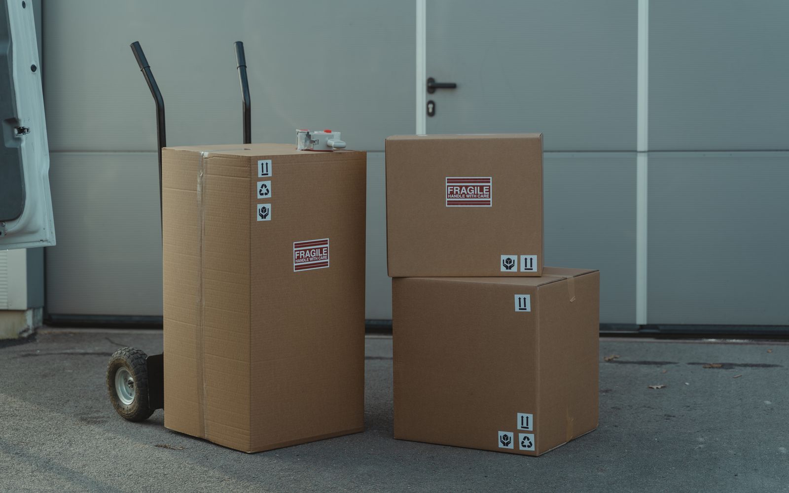 Três caixas de papelão em um carrinho, prontas para envio