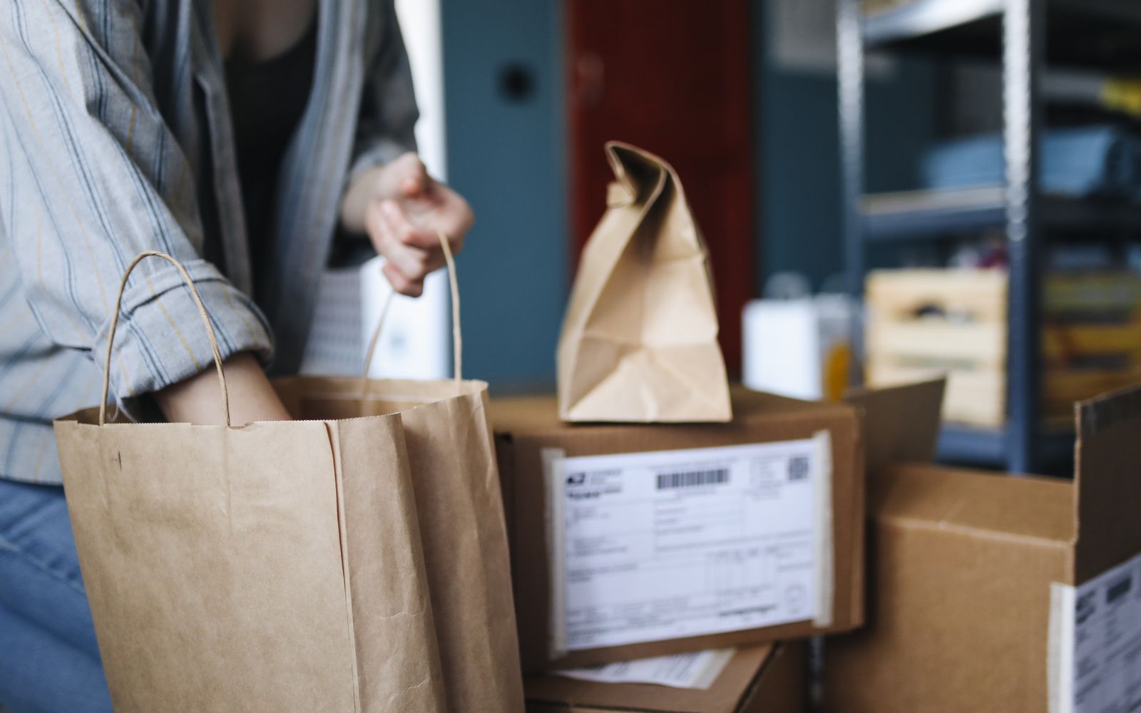 Mulher organizando encomendas e sacolas de compras em casa