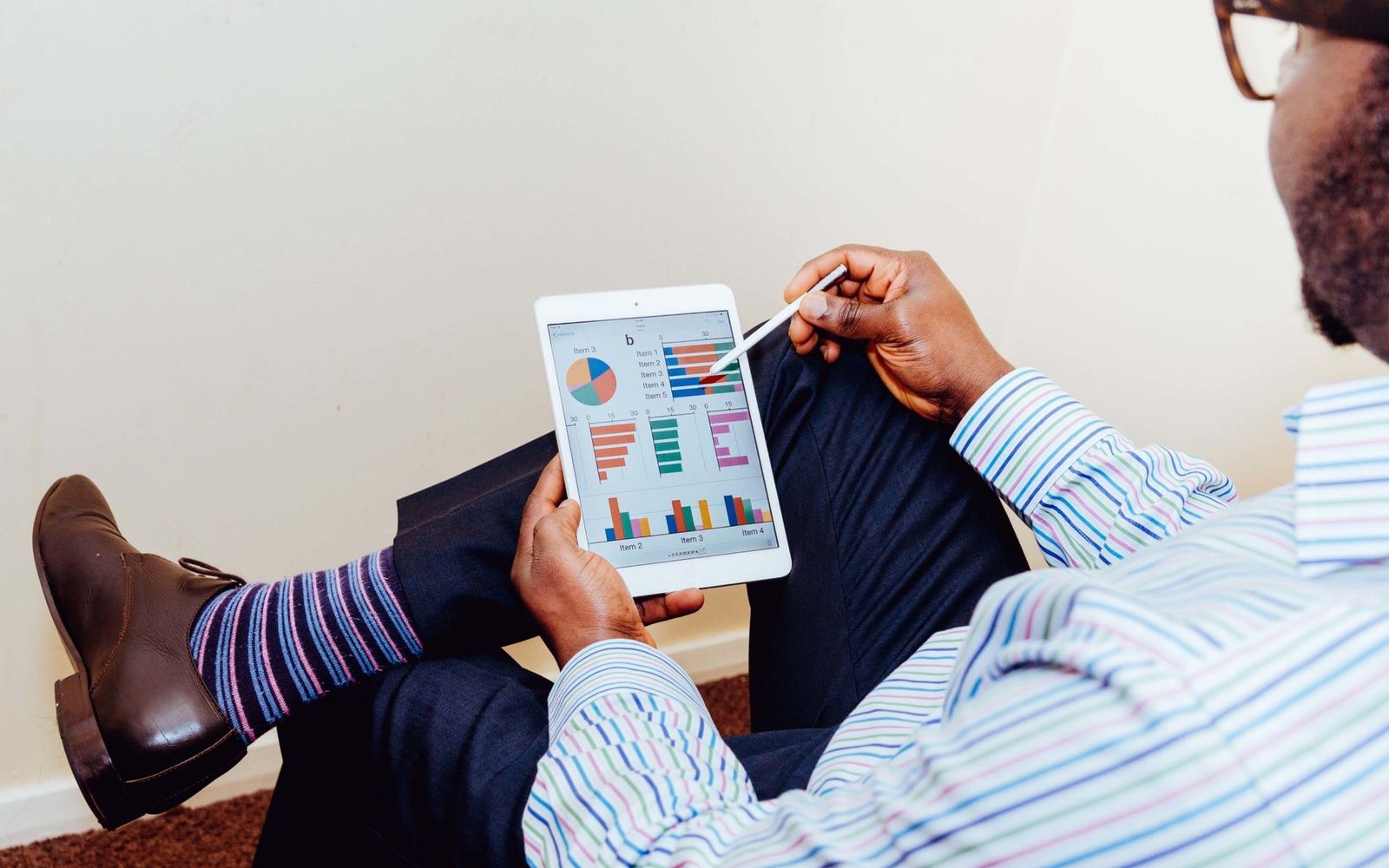 Homem analisando dados em um tablet no escritório