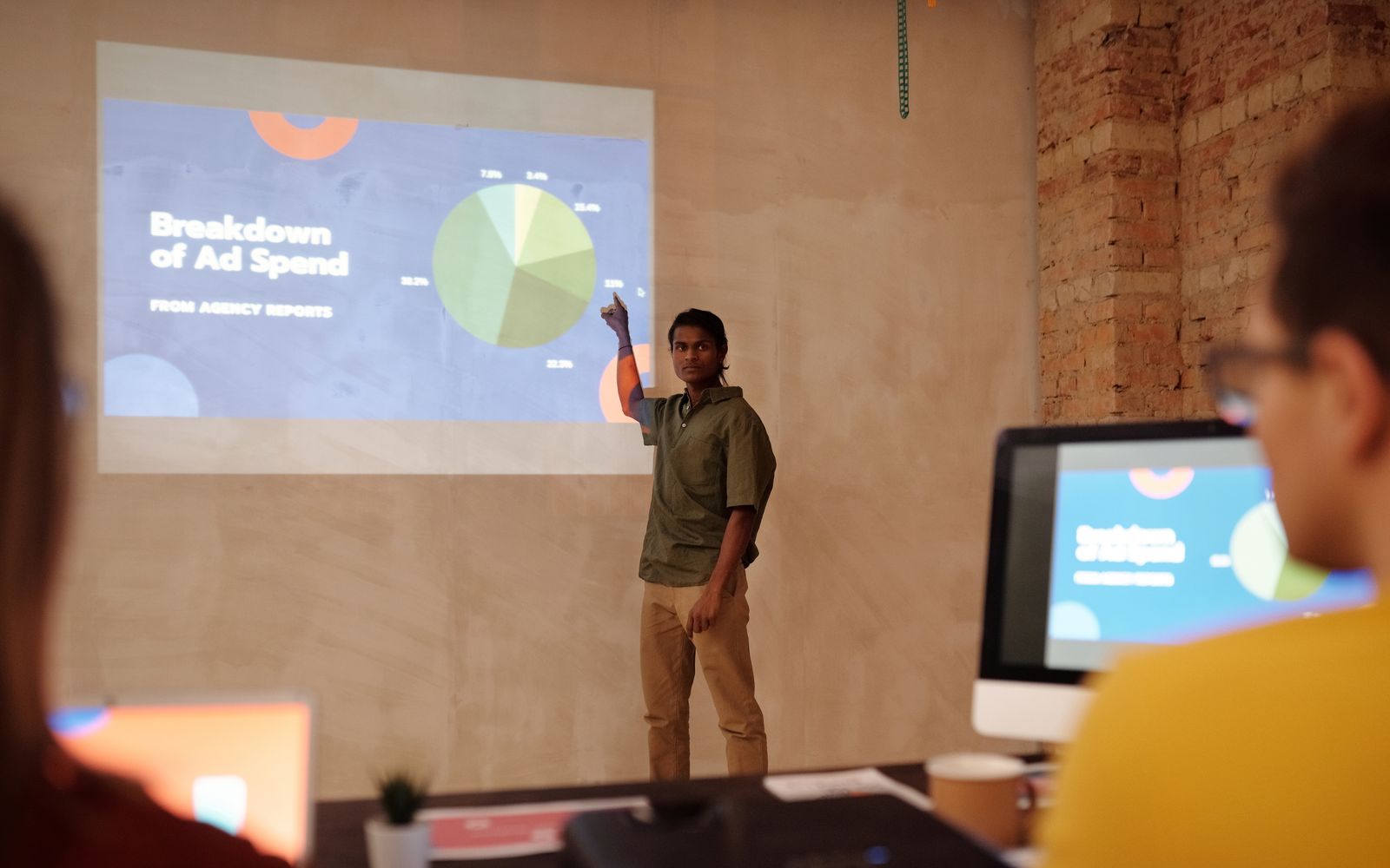 Jovem apresentando gráficos de investimento em anúncios em um escritório