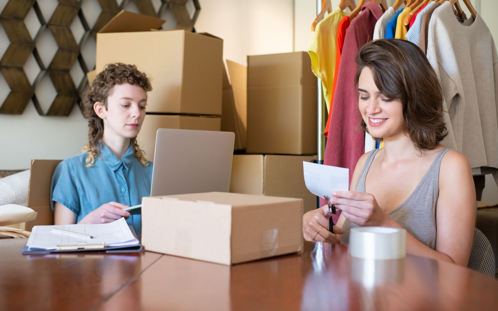 Duas mulheres organizando os pedidos de uma loja de roupas online