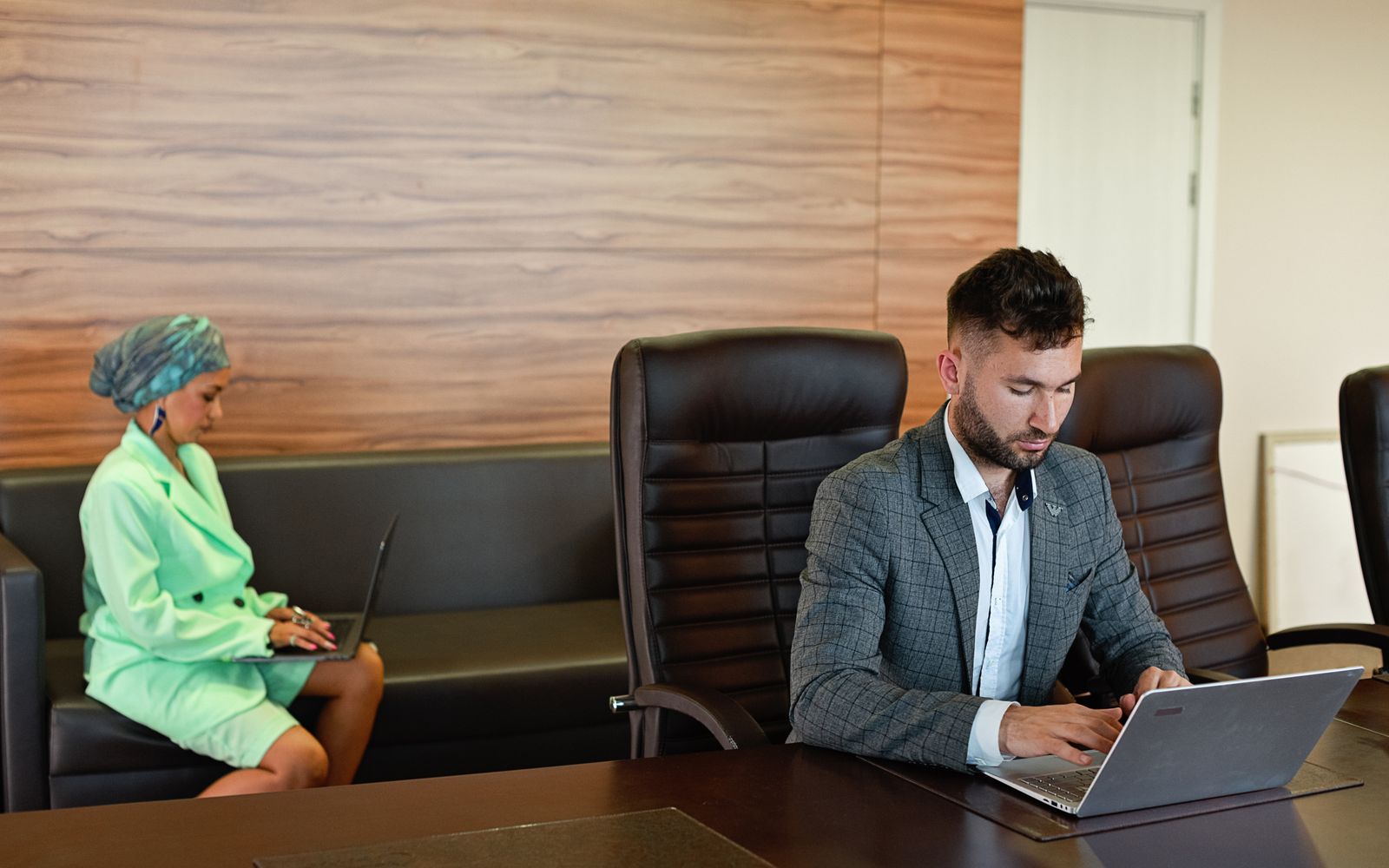 Dois profissionais concentrados no trabalho com laptops em um ambiente de escritório moderno