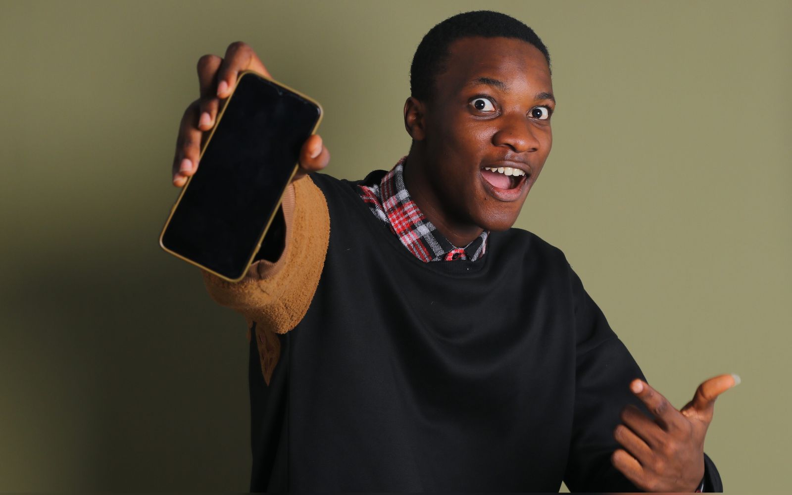 Homem sorrindo e apontando para a tela de um celular