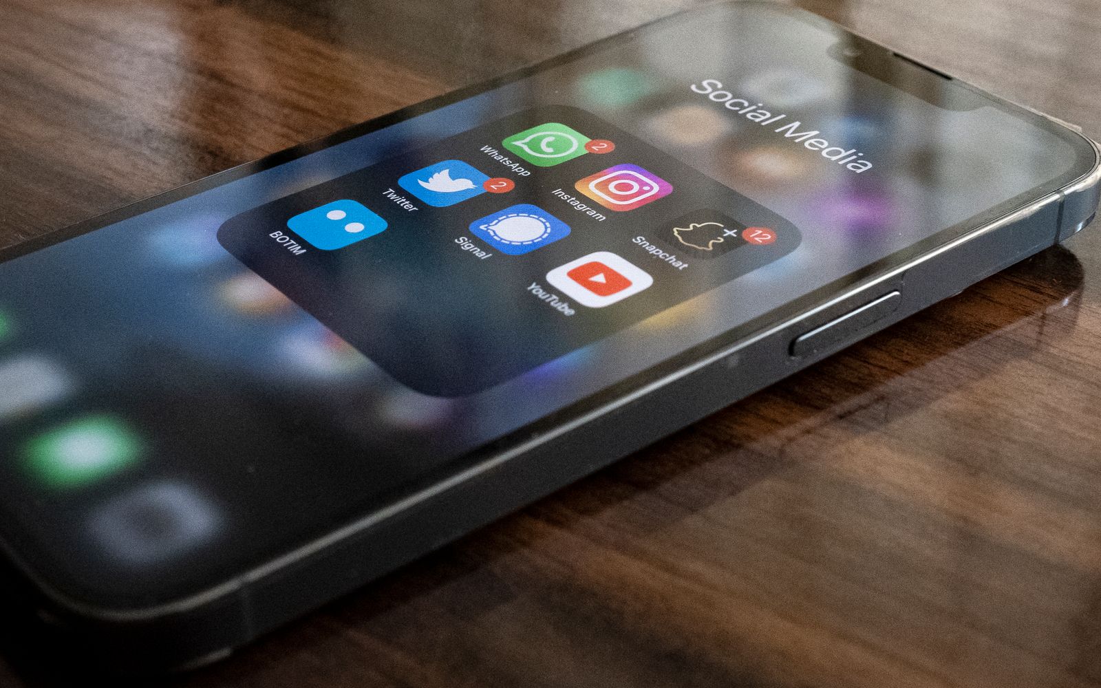 Celular sobre a mesa com ícones de aplicativos, entre eles WhatsApp e Instagram