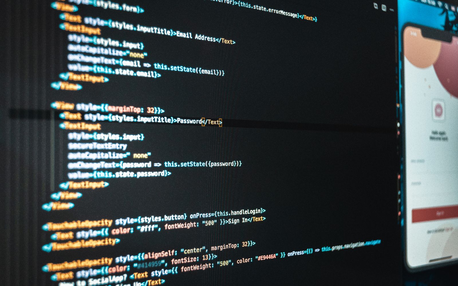 Tela de computador com código e aplicativo abertos em escritório