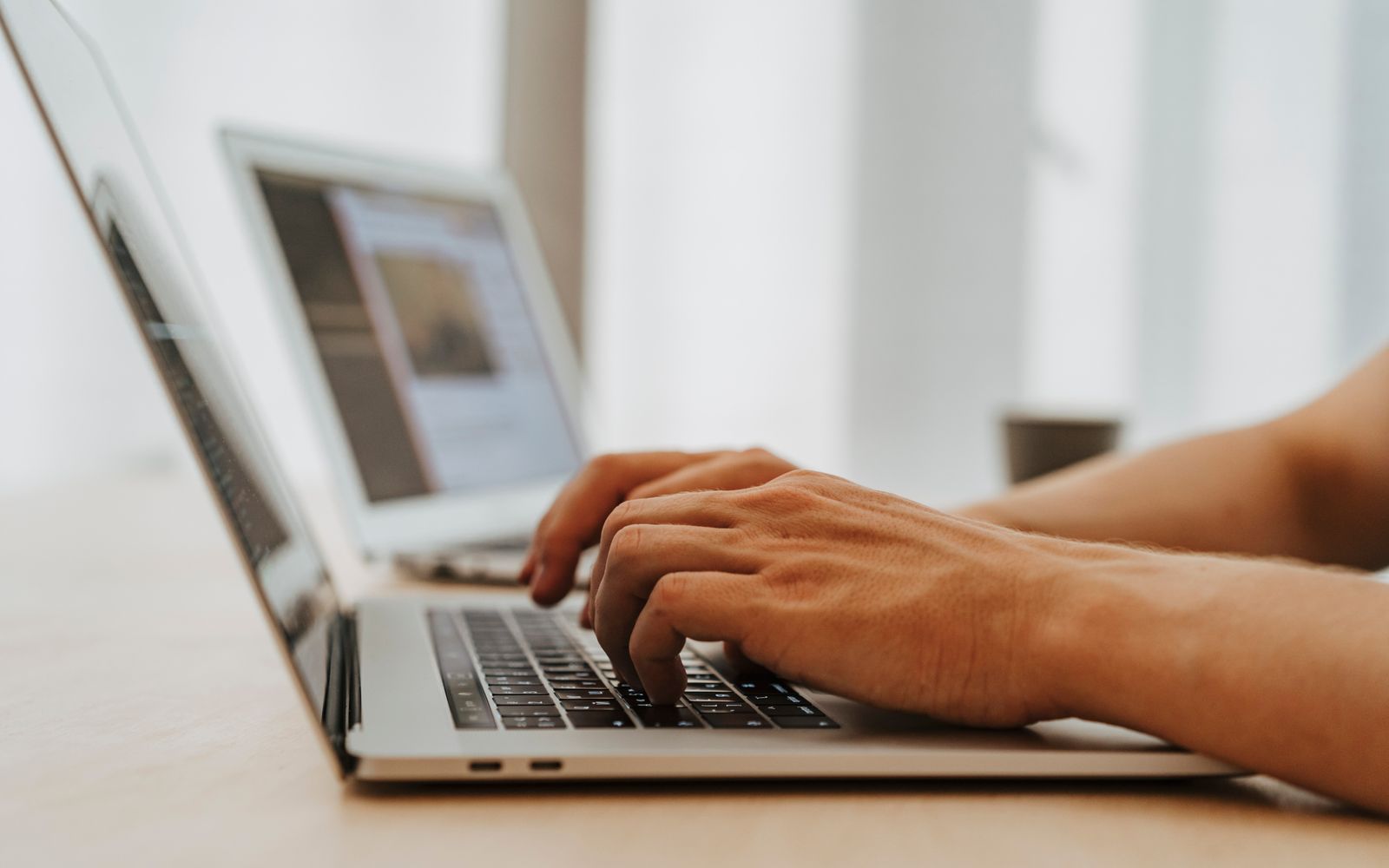 Visão focada das mãos digitando em um laptop