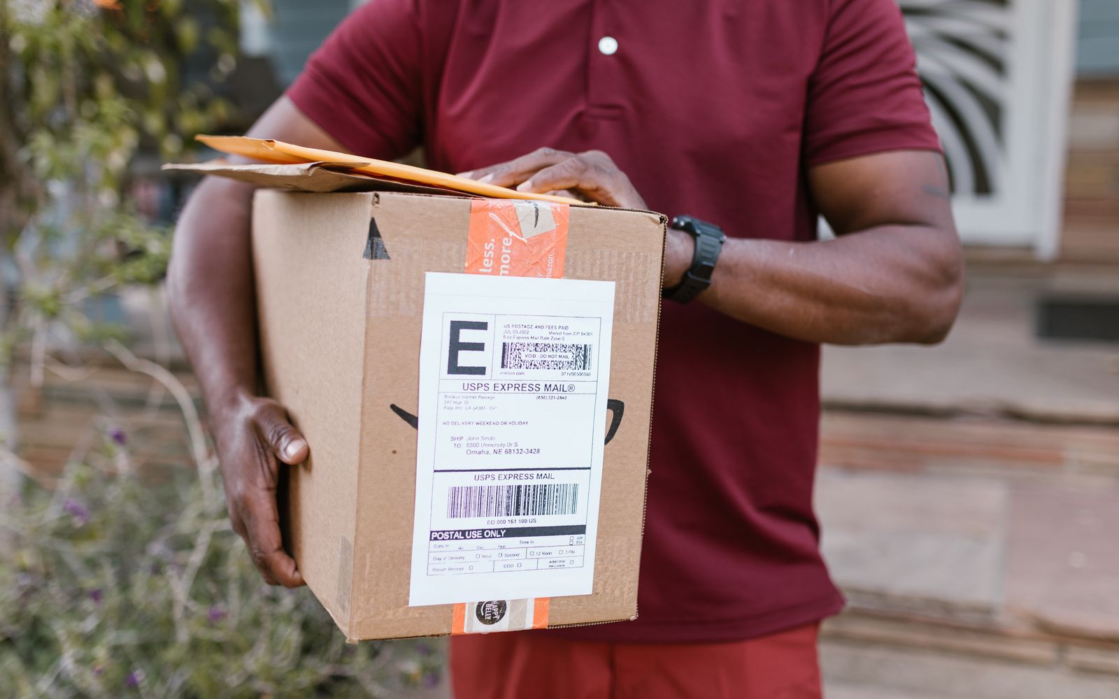 Entregador com uma encomenda de correio expresso na mão
