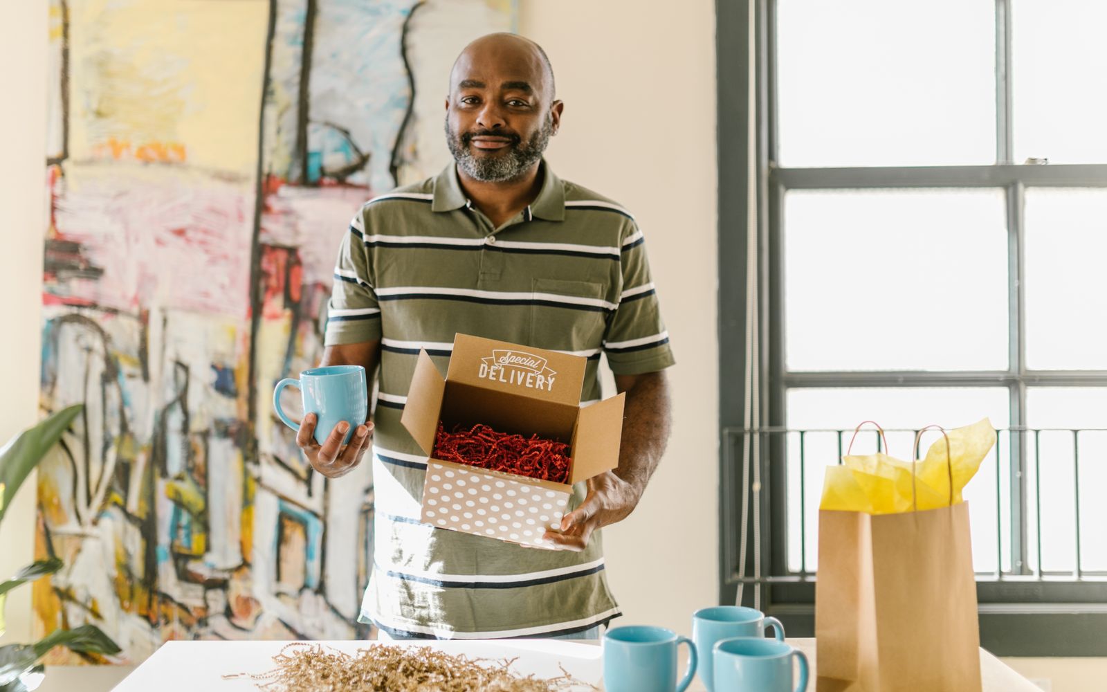 Homem embalando canecas azuis para entrega