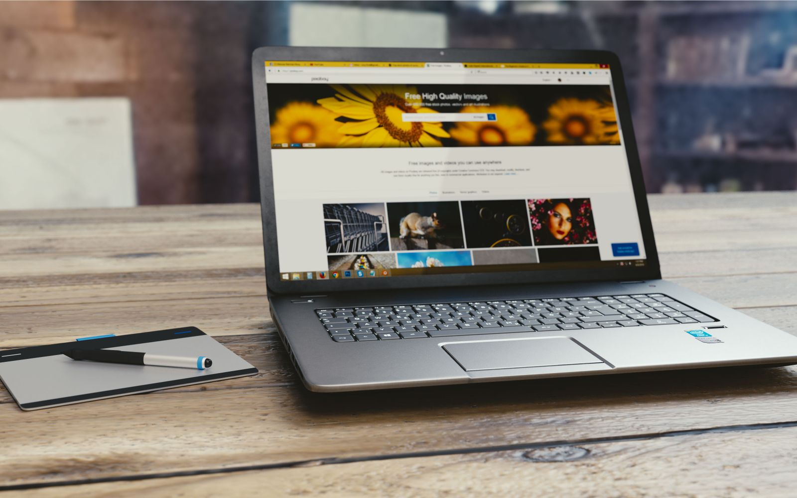 Notebook com uma página aberta sobre mesa de madeira, ao lado de tablet e caneta