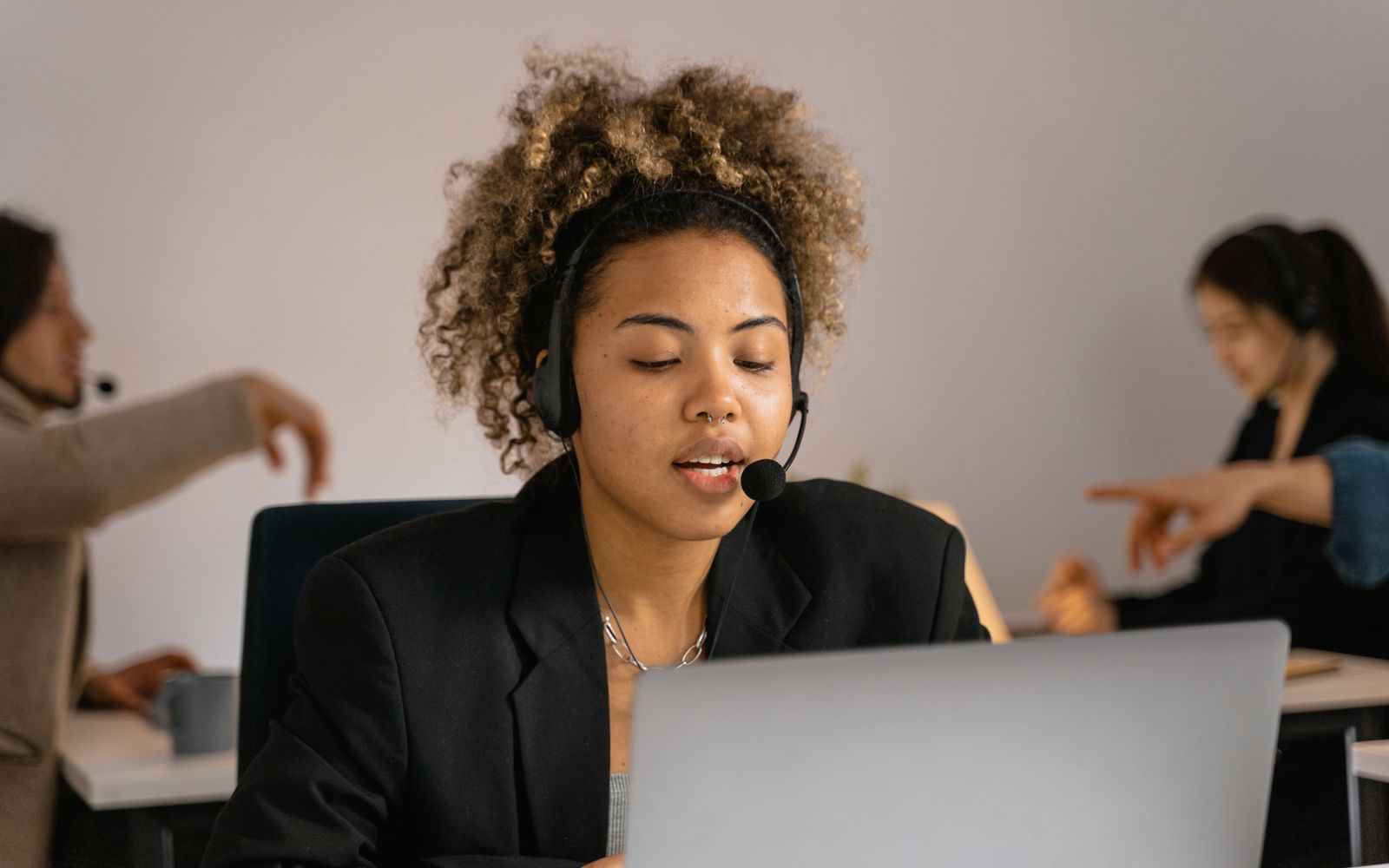 Atendente de headset trabalhando no notebook em escritório