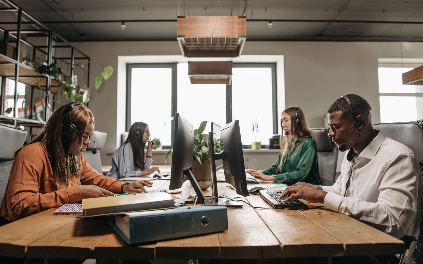 Equipe diversa de atendimento com headset em escritório moderno
