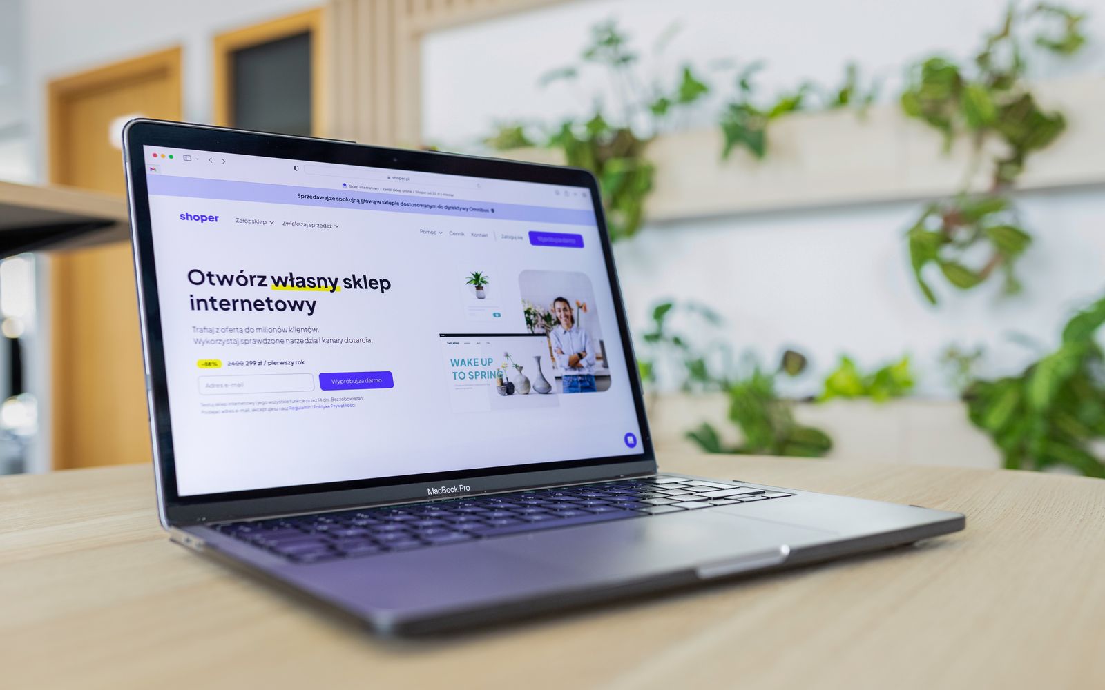 Um laptop com um site de e-commerce aberto, cercado por decoração de escritório moderna