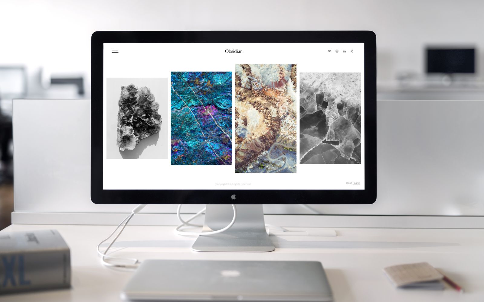 Mesa de escritório com monitor exibindo uma arte abstrata