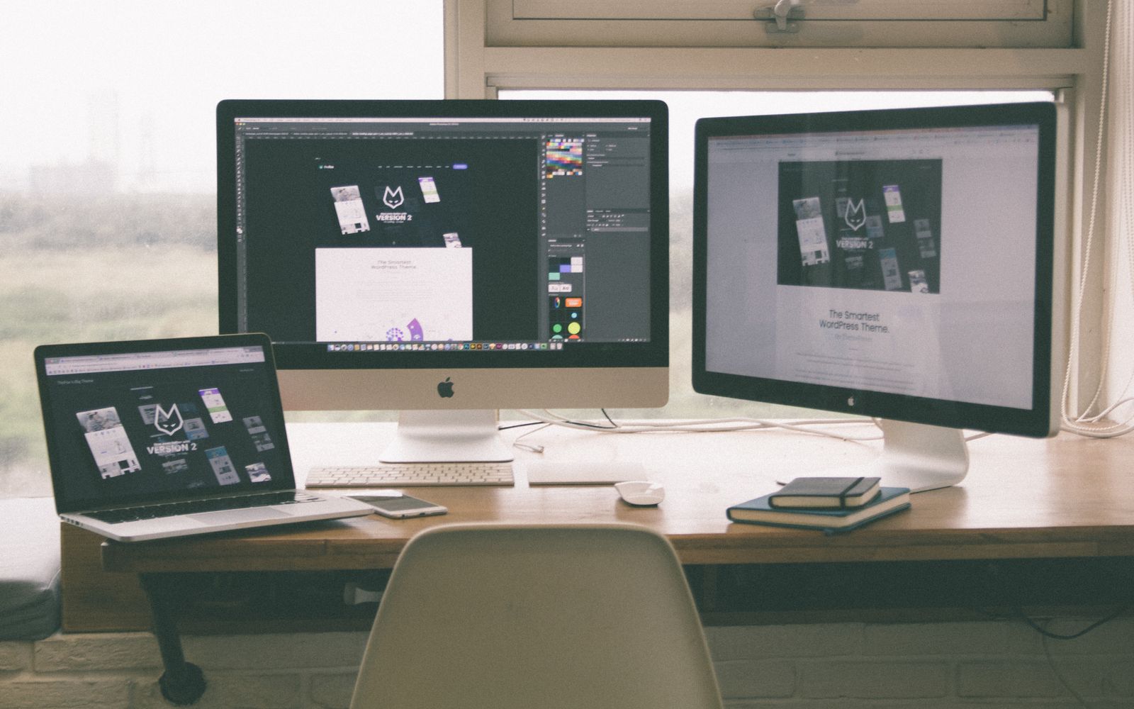 Estação de trabalho com vários monitores exibindo um projeto de web design