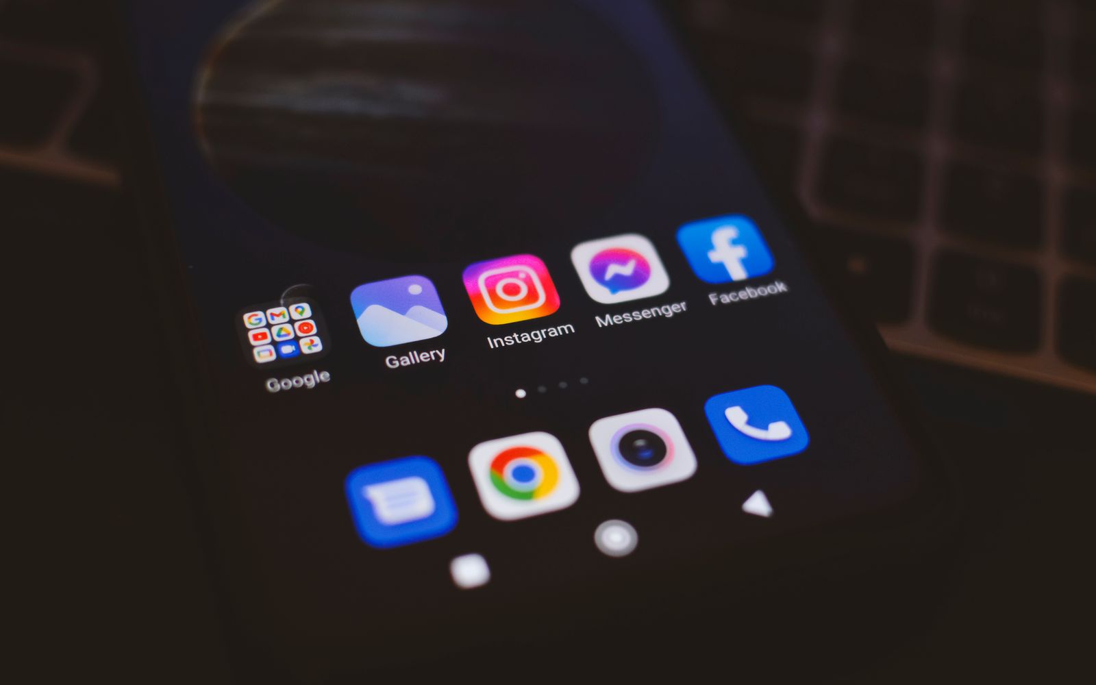 Celular exibindo aplicativos de redes sociais em ambiente com pouca luz