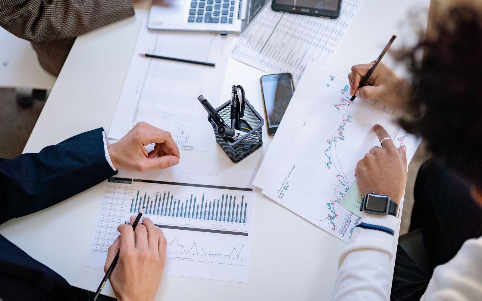 Equipe de negócios analisando gráficos e tabelas financeiras durante uma reunião colaborativa