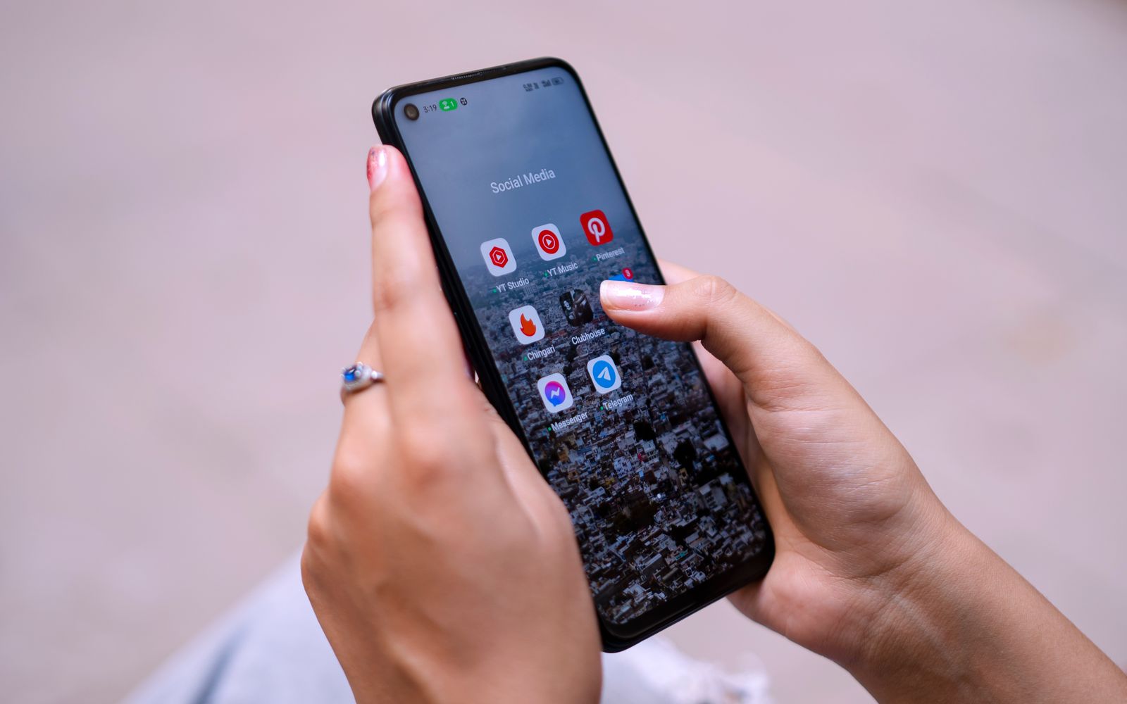 Mãos segurando celular com os aplicativos de redes sociais